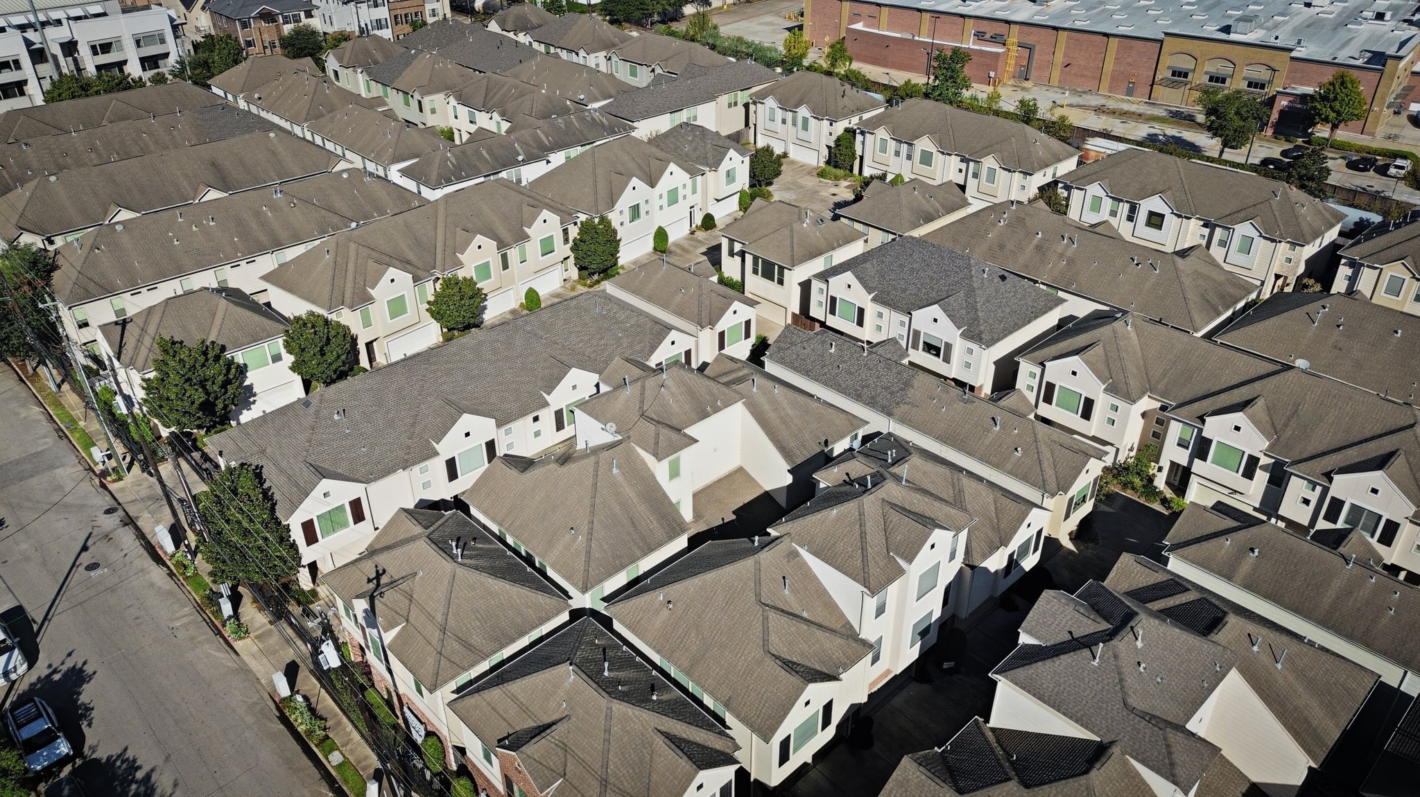 An elevated aerial view captures the neighborhoods extensive layout, showcasing rows of multi-story homes, consistent rooflines, and an organized residential setting.