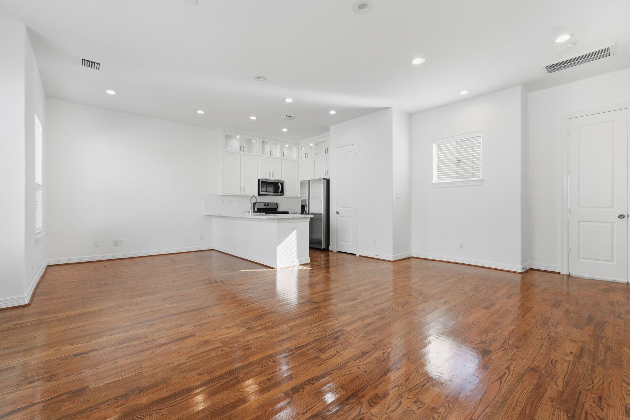 The spacious main living area features an open layout, recessed lighting, and expansive polished floors, offering a versatile setting for a variety of living and entertaining arrangements. (2nd floor)