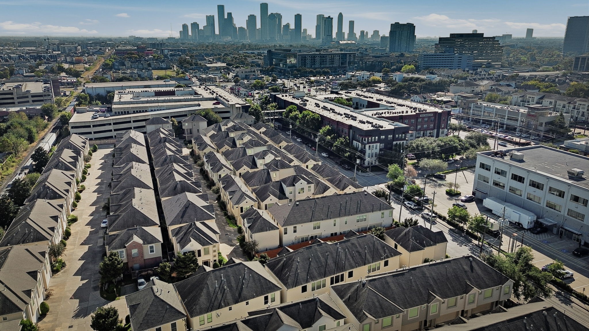 Aerial view highlighting the community's urban setting and proximity to the Downtown Houston skyline, with nearby dining, shopping, and entertainment.