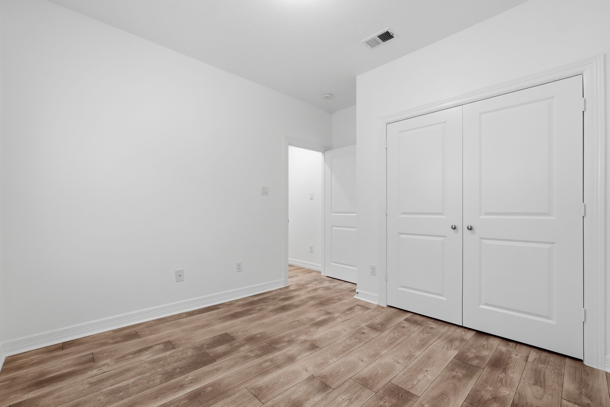 Another view highlights the bedrooms wall space, double-door closet, and clean, neutral finishes, providing a functional layout with room to personalize. (1st floor)