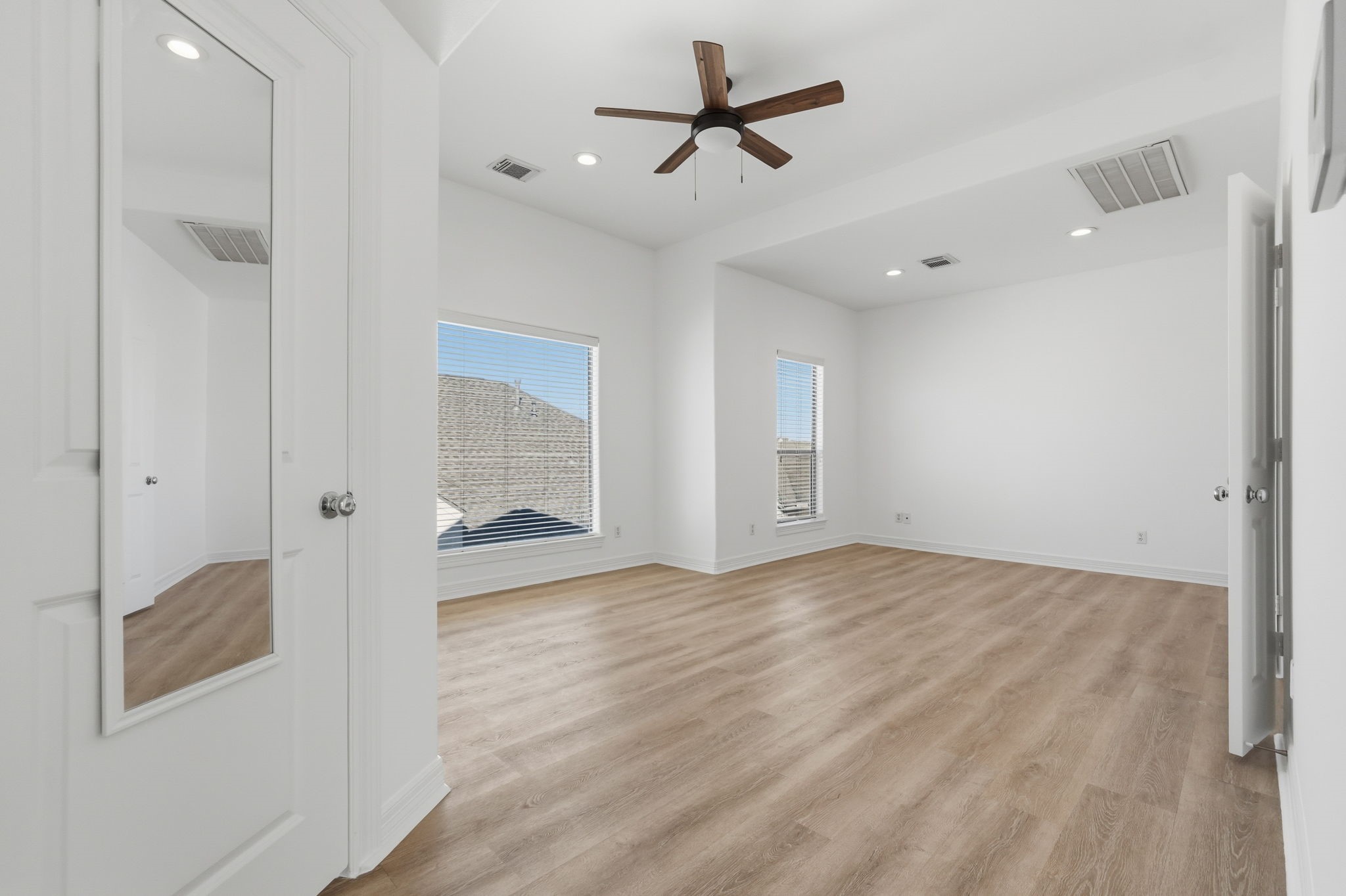 The primary bedroom features a spacious layout, vaulted ceilings, a ceiling fan, and large windows that invite natural light, creating a bright and airy retreat with a clean, modern feel. (3rd floor)