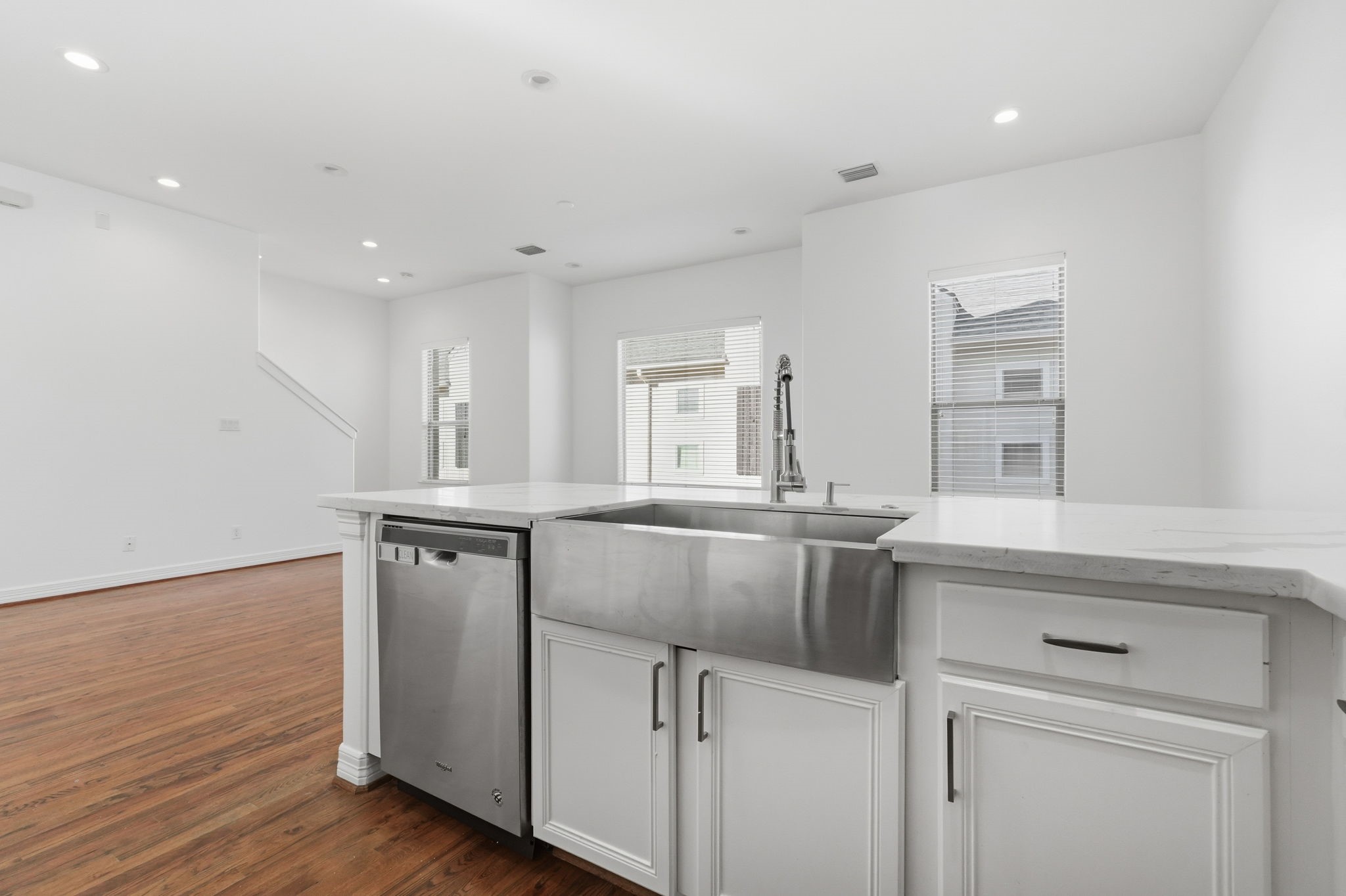 The kitchen features a spacious countertop, a deep stainless steel farmhouse sink, and built-in dishwasher, complemented by crisp white cabinetry for a practical and polished cooking space. (2nd floor)