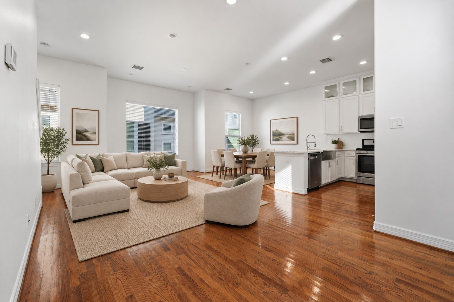 (Virtually staged) Bright, open-concept living and dining areas showcase recessed lighting, clean architectural lines, and a soft neutral palette, creating a seamless flow and a welcoming atmosphere for everyday living.