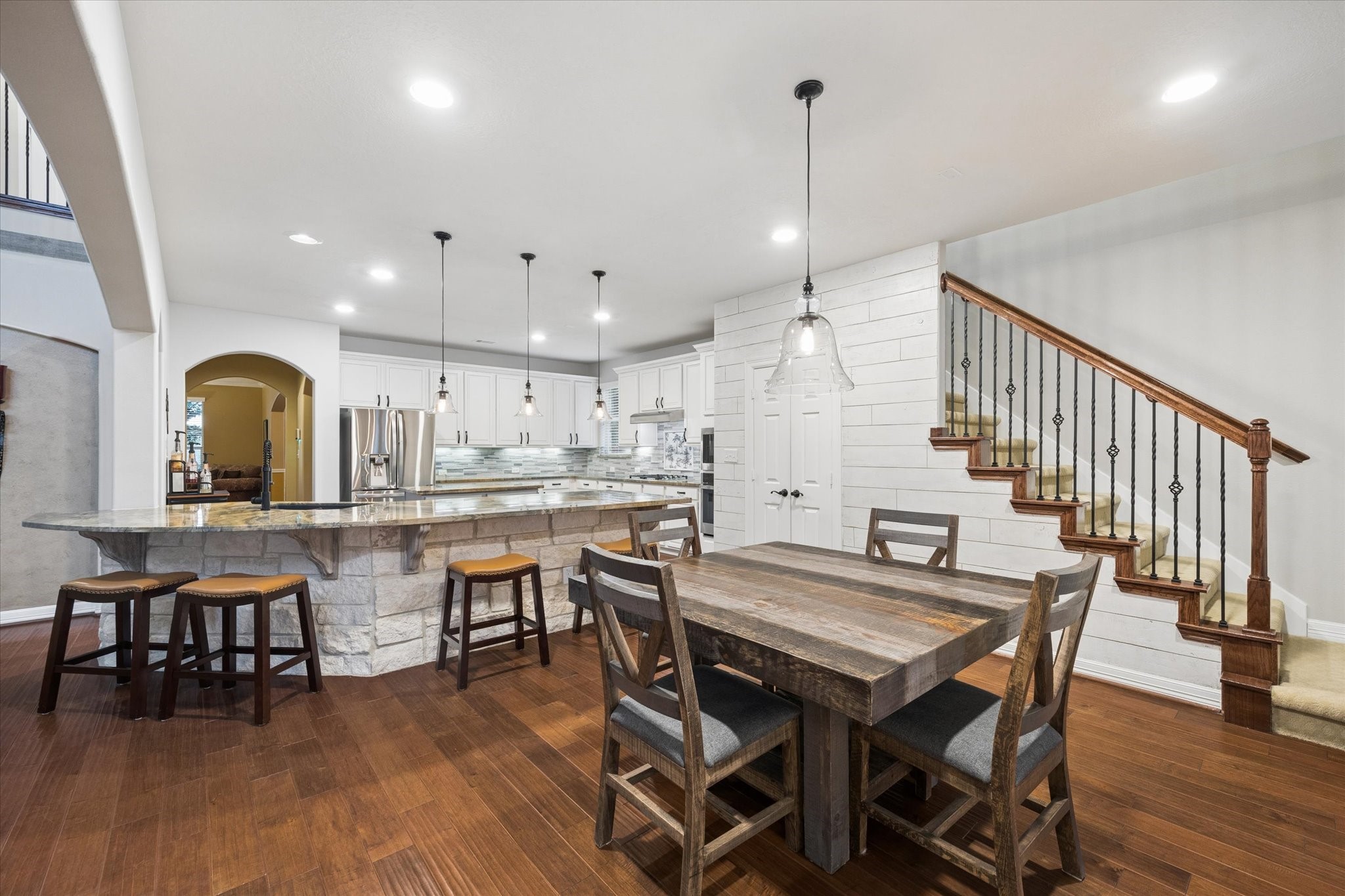 The spacious breakfast area flows seamlessly from the kitchen, offering the perfect setting for casual dining and everyday gatherings. A generous breakfast bar provides additional seating, while recessed LED lighting and the open-concept design create a bright and inviting connection between the kitchen and surrounding living spaces.