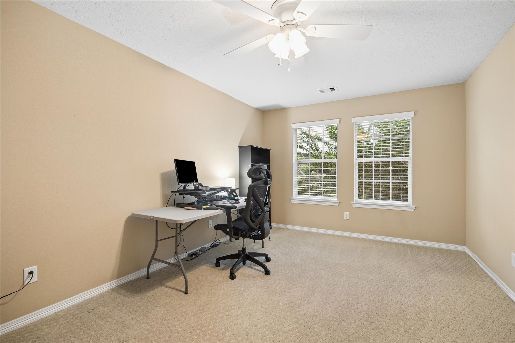 Another inviting secondary bedroom filled with natural light and offering a generous layout, creating a comfortable and welcoming retreat for family or guests.