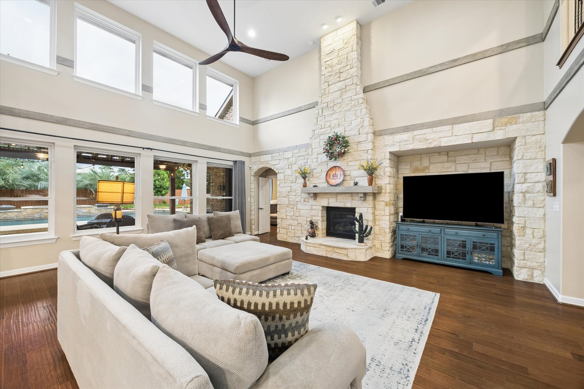 Expansive windows fill the family room with natural light while offering beautiful views of the backyard and resort-style pool. Soaring ceilings and the impressive floor-to-ceiling stone fireplace create a warm and inviting space to relax and enjoy the homes exceptional indoor-outdoor setting.