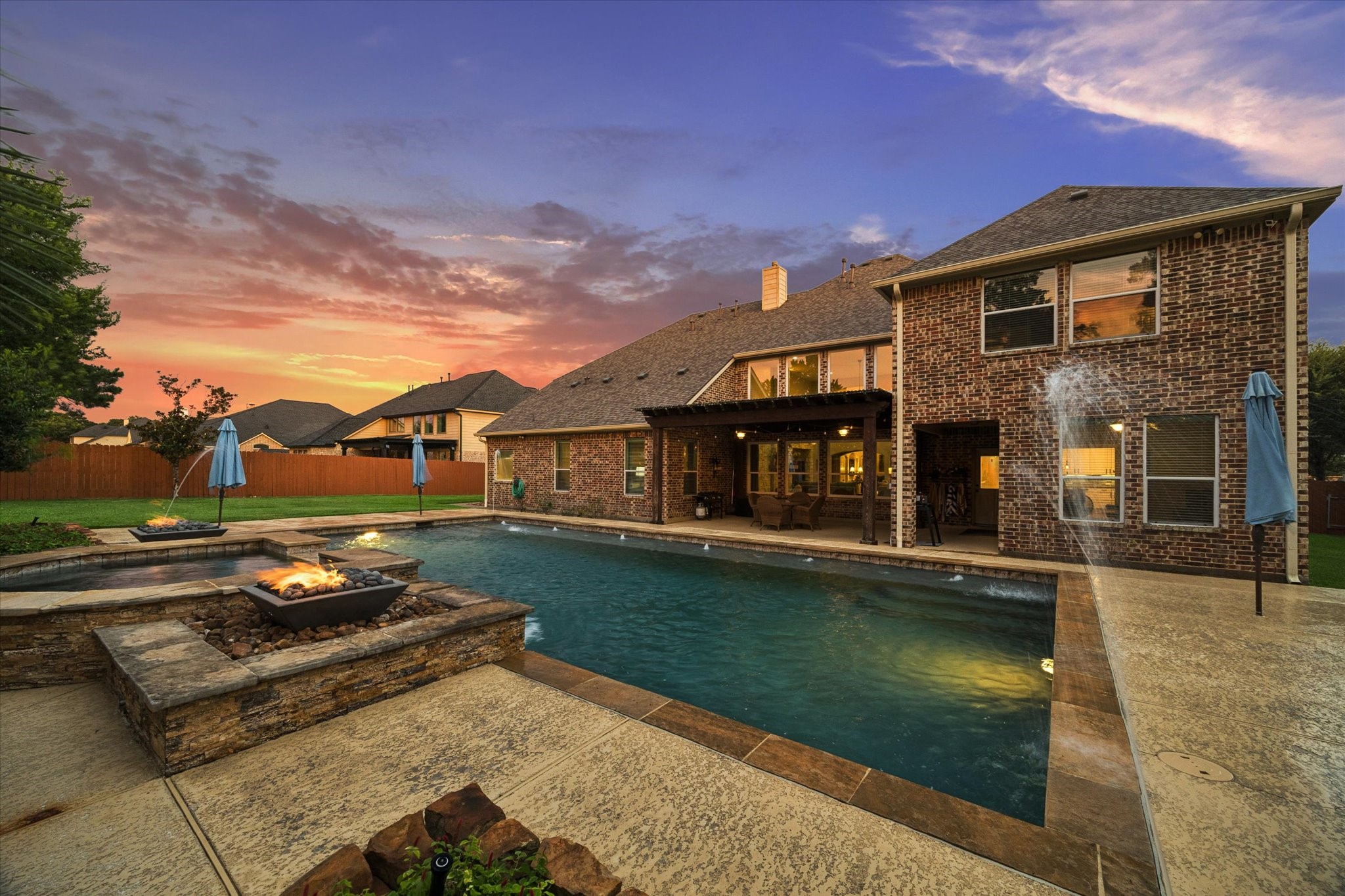Enjoy unforgettable evenings in this beautifully designed outdoor oasis, featuring an impressive pool, dramatic fire and water elements, and a covered patio ideal for year-round outdoor livingall framed by a stunning Texas sunset.