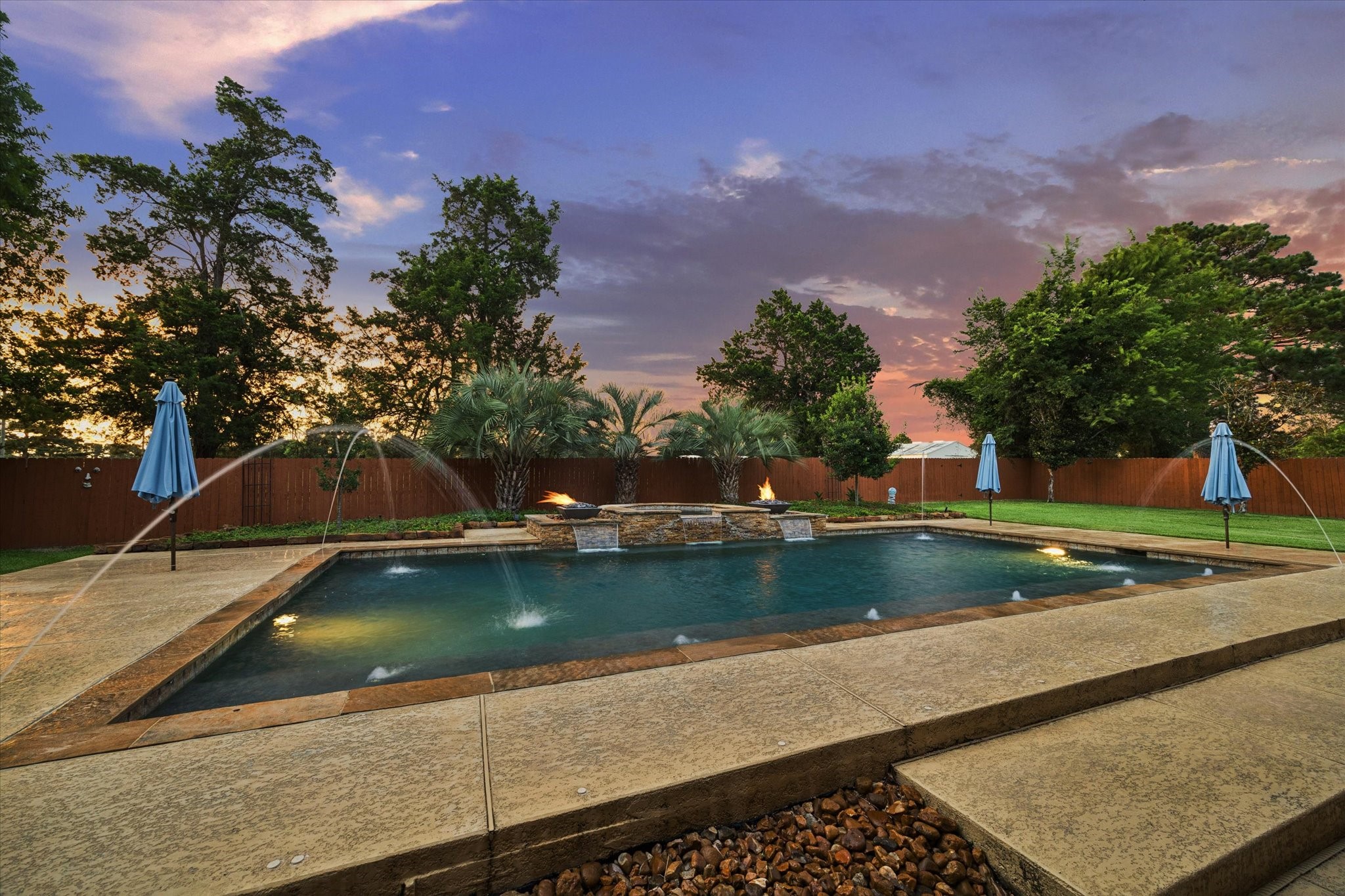 A spectacular backyard retreat featuring a resort-style pool with cascading water features, fire accents, and lush landscapingan exceptional setting for relaxing, entertaining, and enjoying beautiful Texas evenings.
