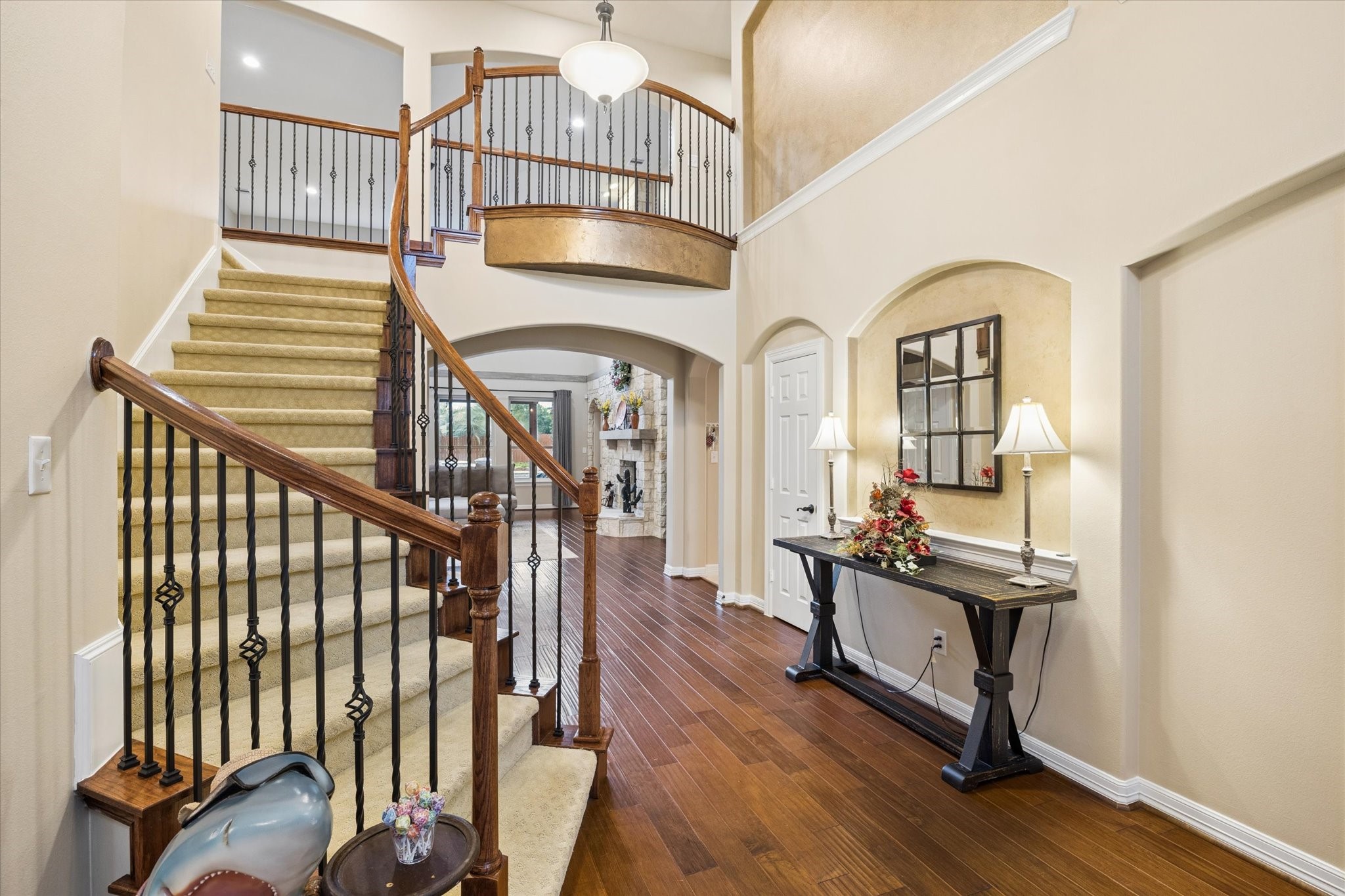 grand entry welcomes you inside, where soaring ceilings, rich hardwood floors, and an elegant staircase create an impressive introduction to the home. Thoughtful architectural details and an open design offer a glimpse of the beautiful spaces beyond.