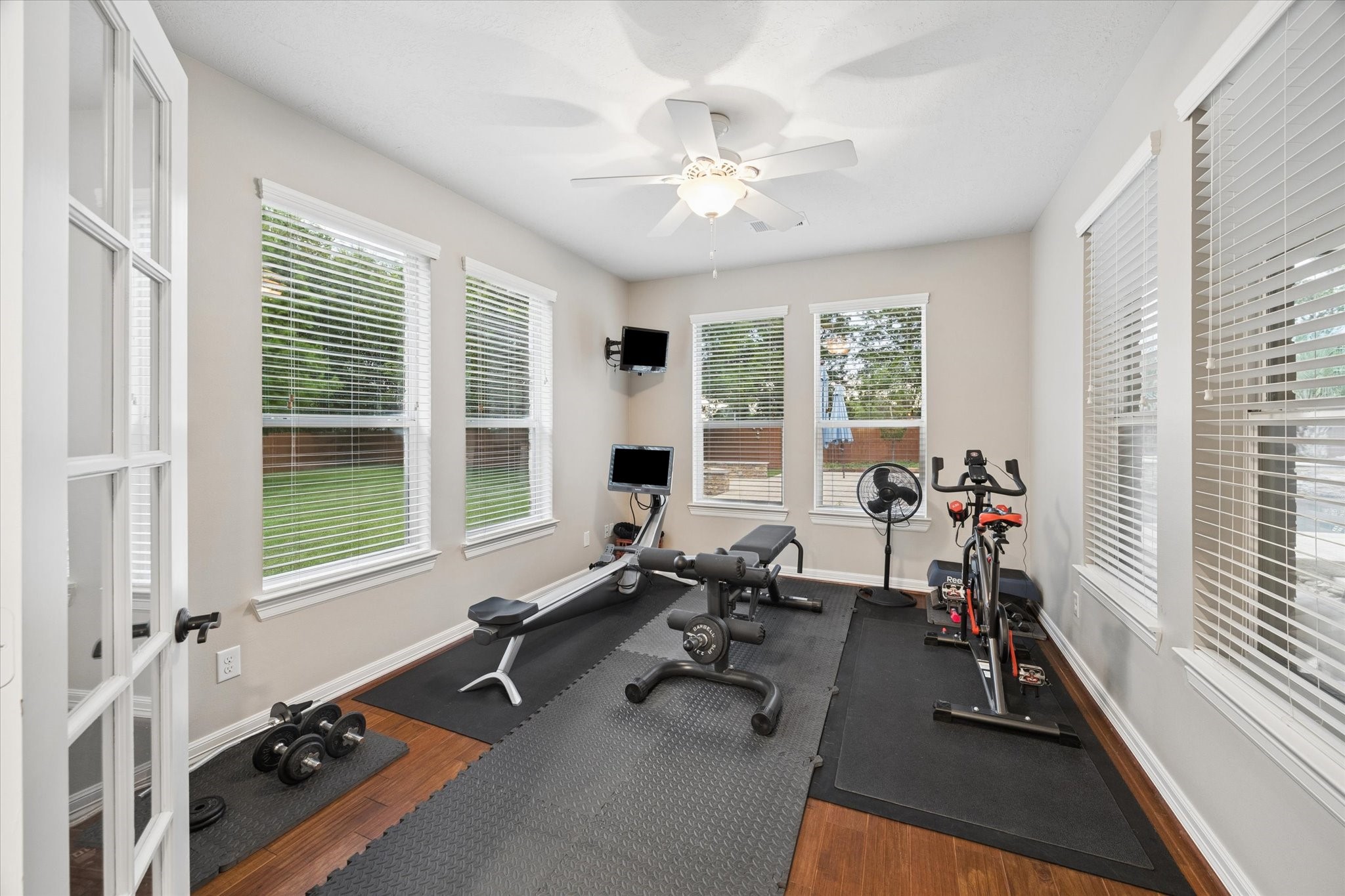 A versatile flex room conveniently located near the main living area offers abundant natural light and views of the backyard. Currently used as a home gym, this flexible space can easily adapt to a private sitting room, home office, fitness studio, or personal retreat.