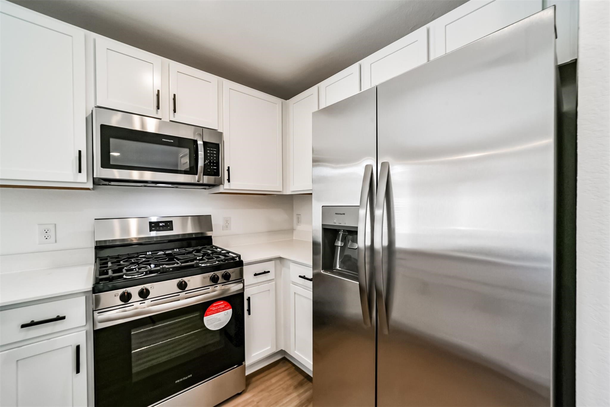 Modern kitchen equipped with stainless steel appliances, including a refrigerator and built-in microwave.