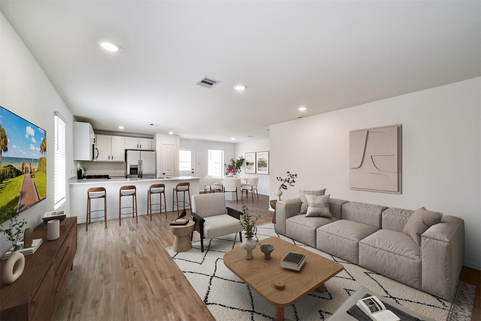 Beautiful open-concept living area connecting seamlessly to the kitchen on the left, featuring a large breakfast bar island with plenty of space for everyday living and entertaining.