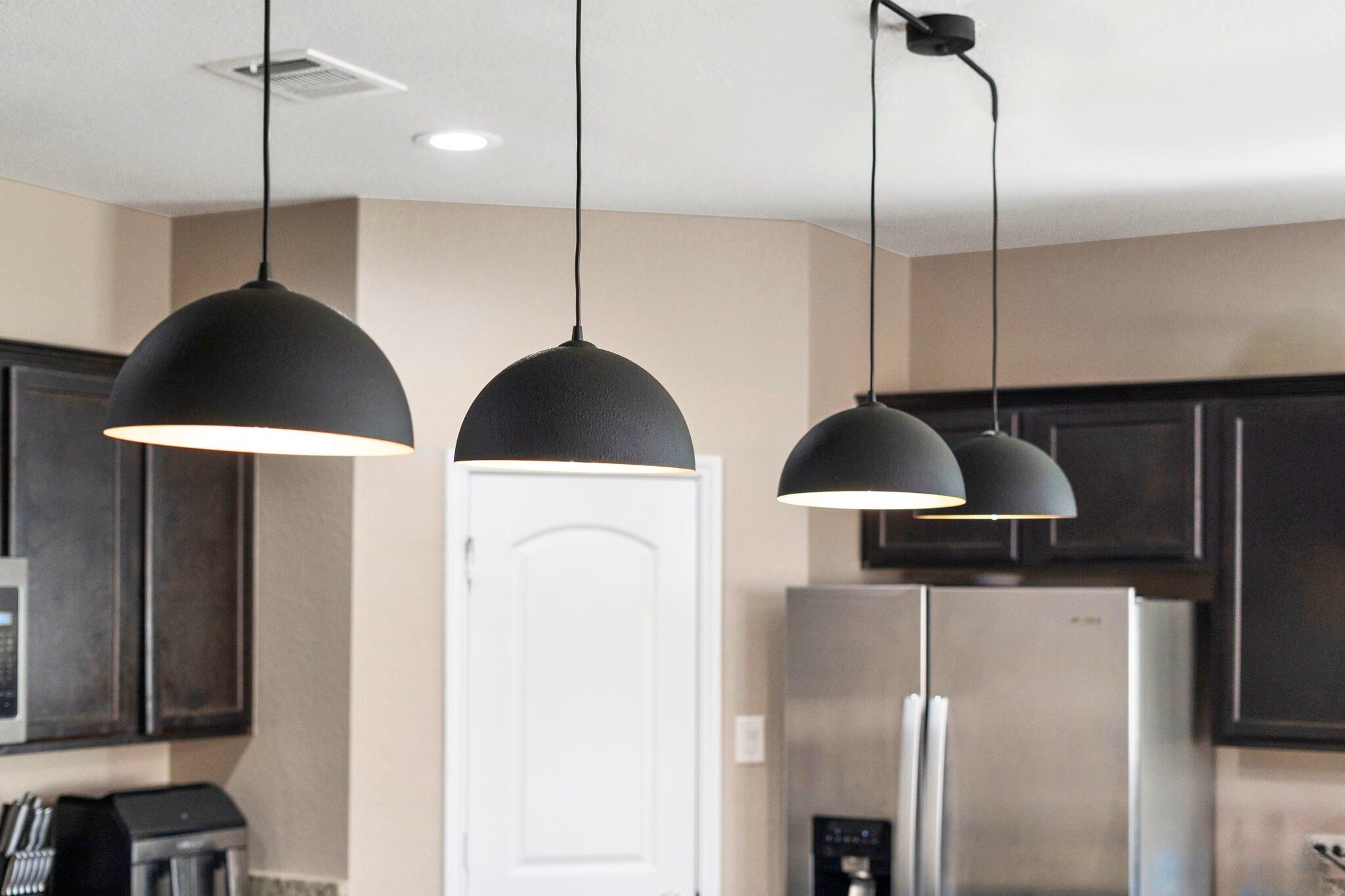 A stylish lighting fixture hangs over the kitchen island, adding a touch of elegance and highlighting the space