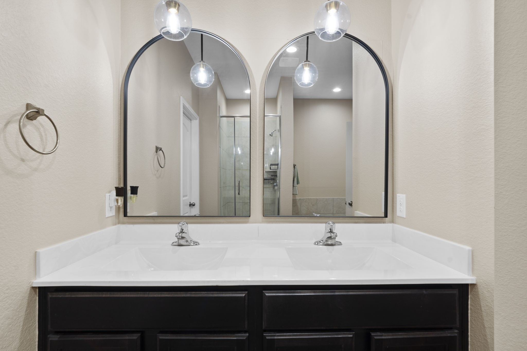 The primary ensuite bathroom features stylish pendant lighting, adding a modern touch and enhancing the rooms ambiance.