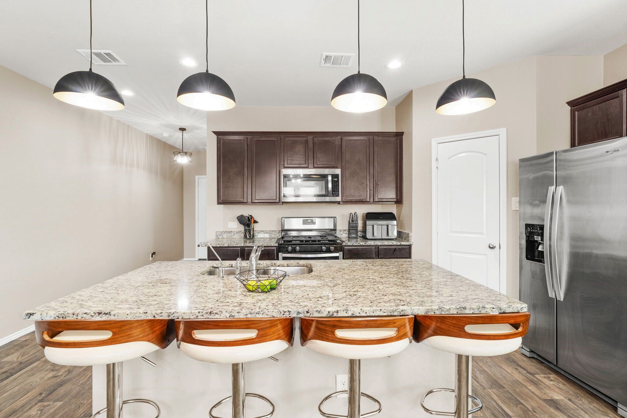 A stylish lighting fixture hangs over the kitchen island, adding a touch of elegance and highlighting the space.