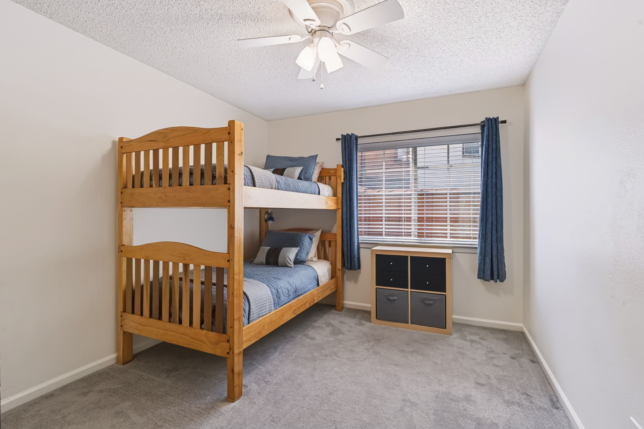This bedroom features neutral-toned carpeting, a large window, and a double-door closet offering plenty of storage.