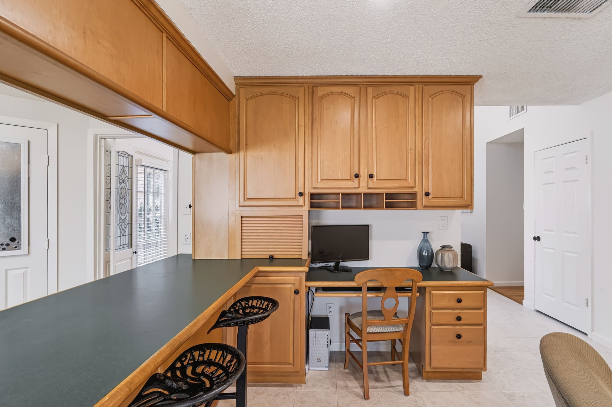 Situated between the kitchen and family room, the built-in desk features custom cabinetry, drawers, and cubbies, creating a functional workspace with plenty of organized storage.