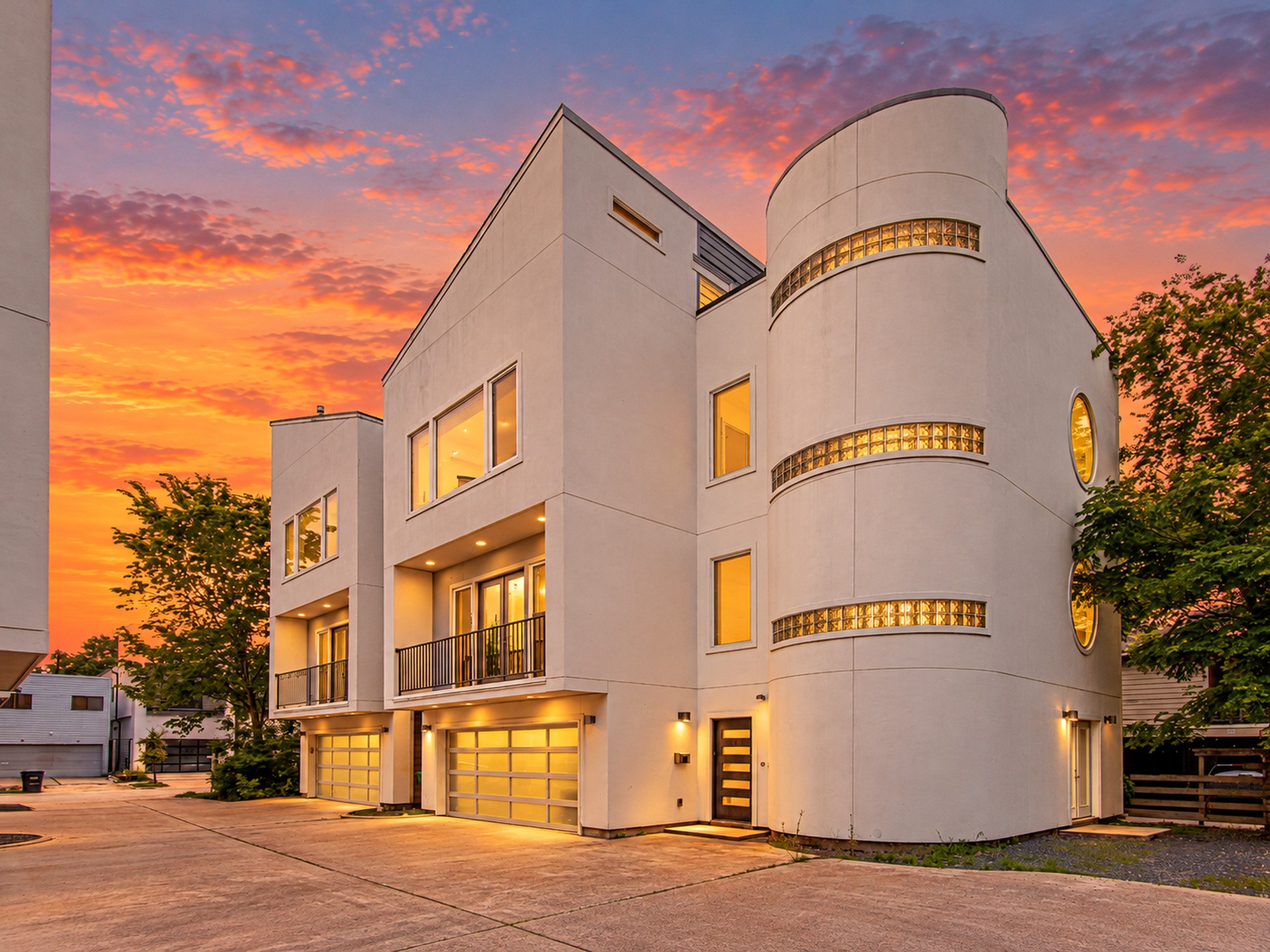 Corner view showcasing the homes curved faade, horizontal accent windows, and modern design.