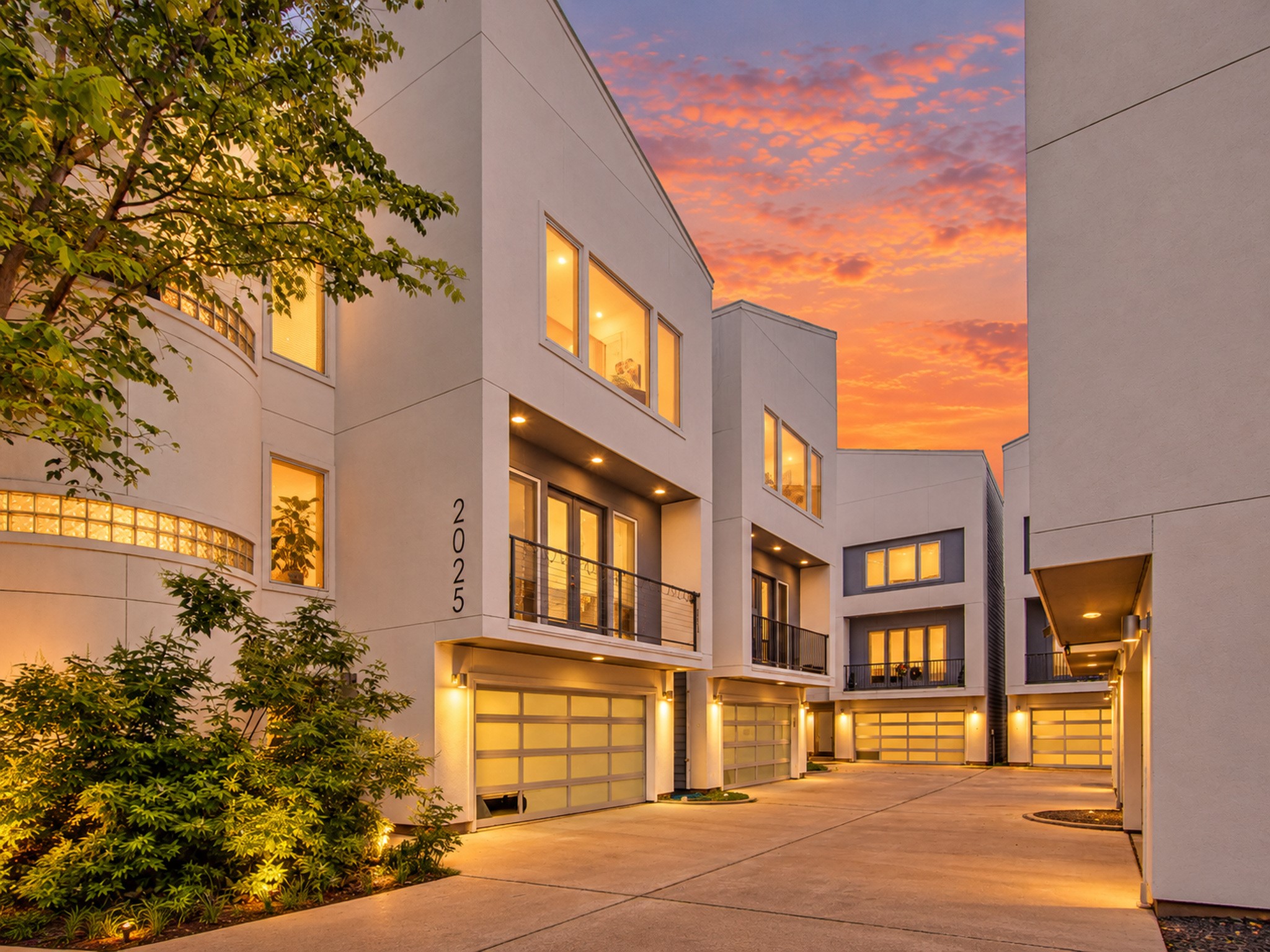 Exterior view highlighting expansive windows, a glass-paneled garage door, and contemporary architectural lines.