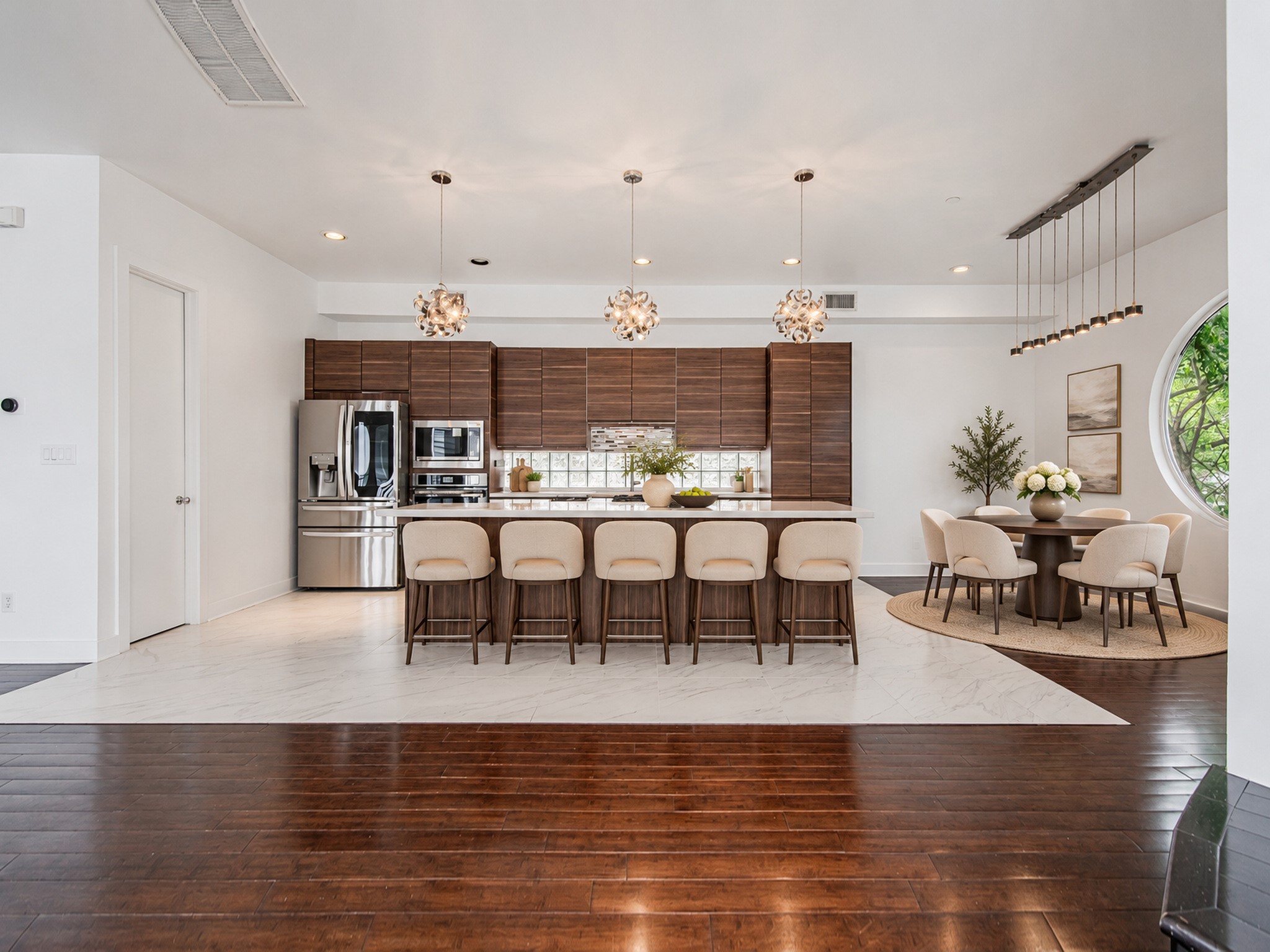 Wide view of the kitchen showcasing generous island seating and an open layout connecting to the surrounding living space.