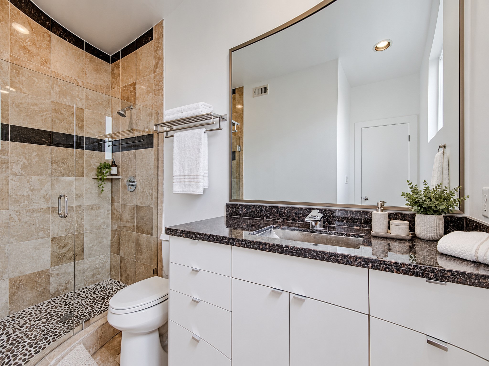 Secondary bathroom with white vanity cabinetry, a dark countertop, and a tiled tub and shower combination.