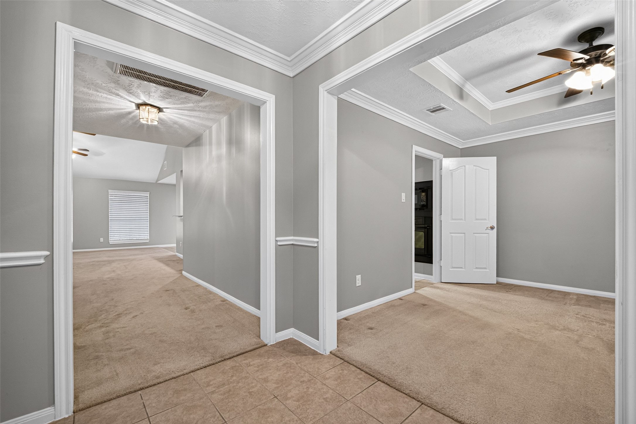 Versatile flex space featuring neutral finishes, decorative trim, and coffered ceiling details.