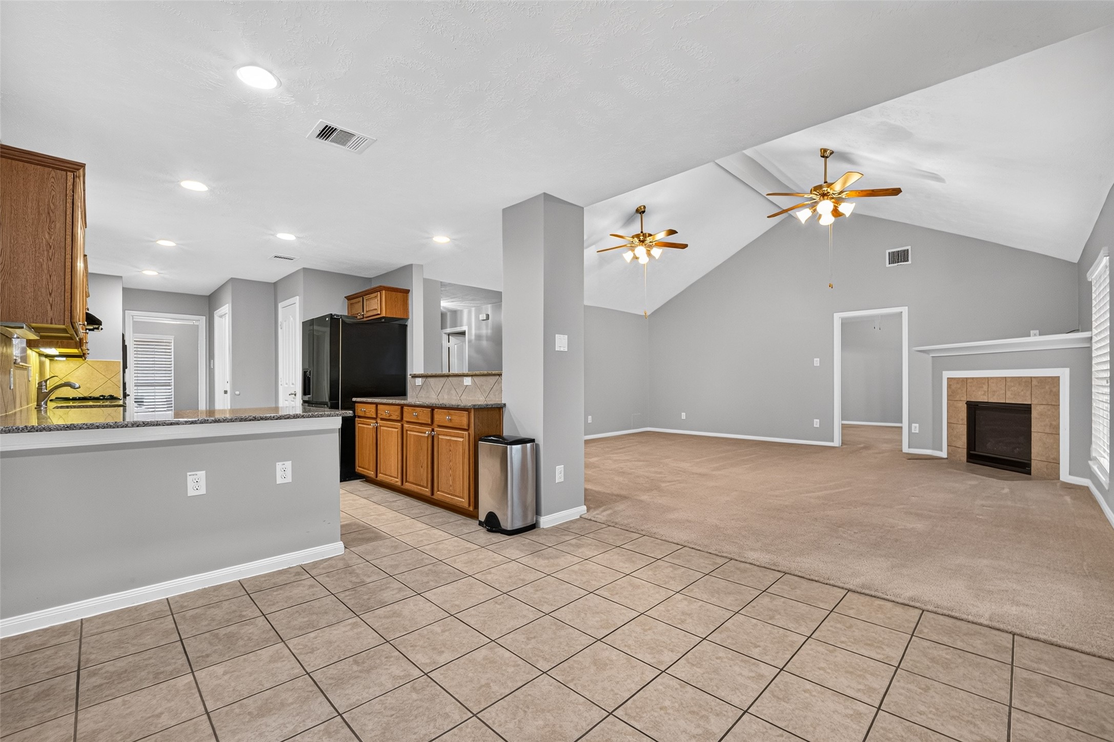 Tile-floored breakfast area opens directly to the carpeted living room, creating a connected layout between the kitchen, dining, and gathering areas.