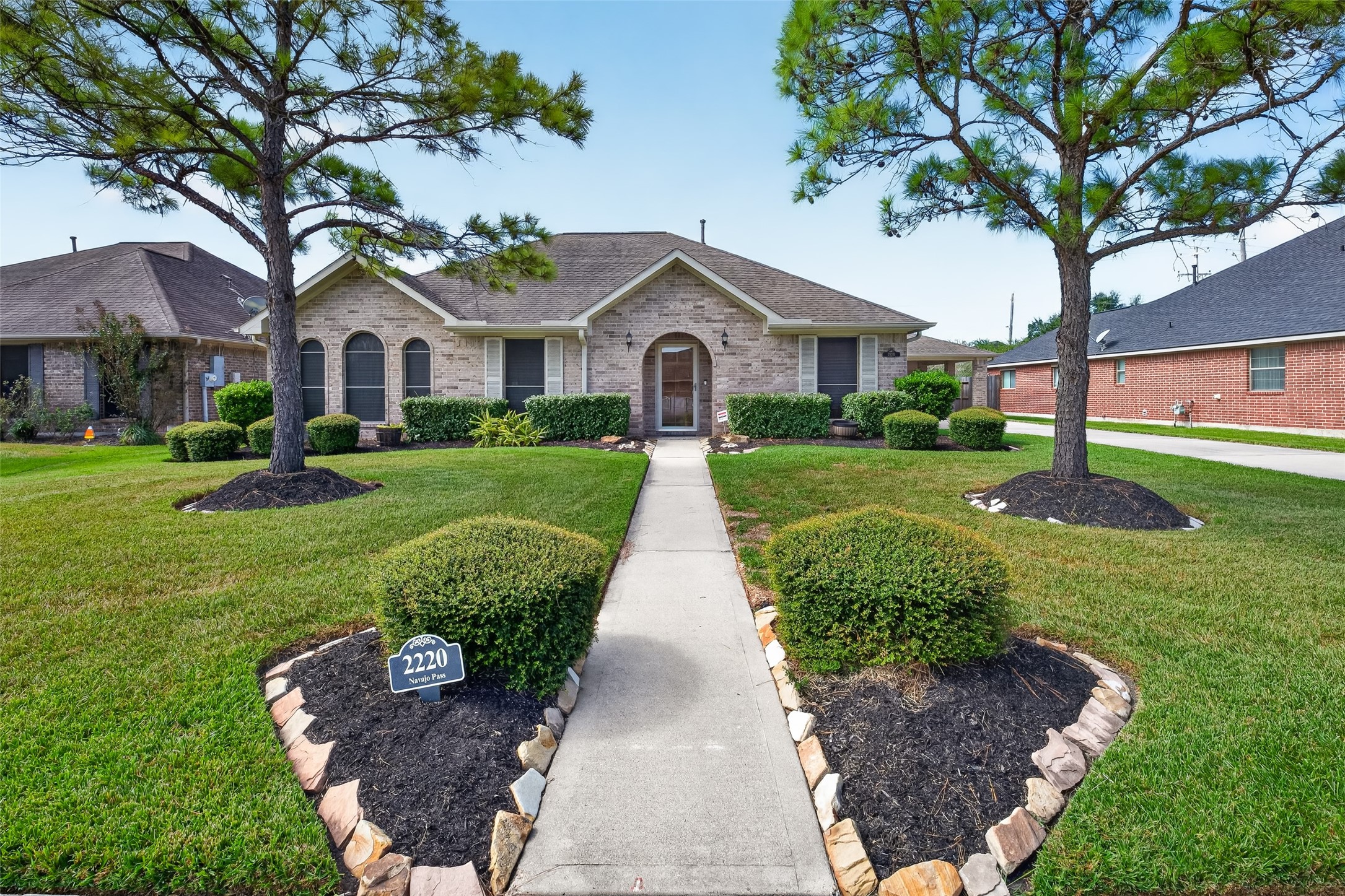Angled exterior view showcases the homes brick facade, multiple roof gables, decorative shutters, and established landscaping along the front elevation. Angled exterior view showcases the homes brick facade, multiple roof gables, decorative shutters, and established landscaping along the front elevation.