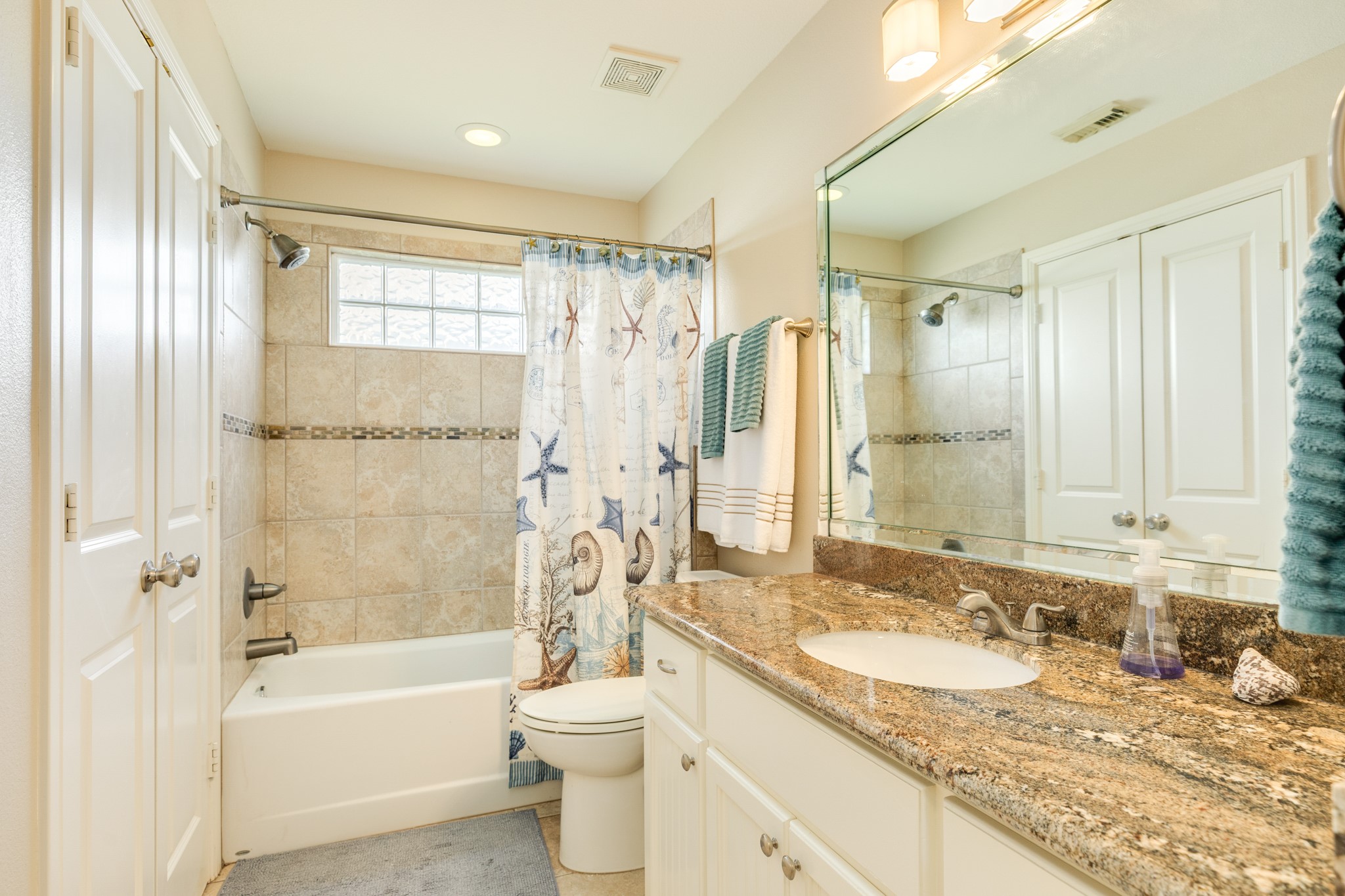 Hall bathroom. The double doors to the left in this view leads into the utility closet.