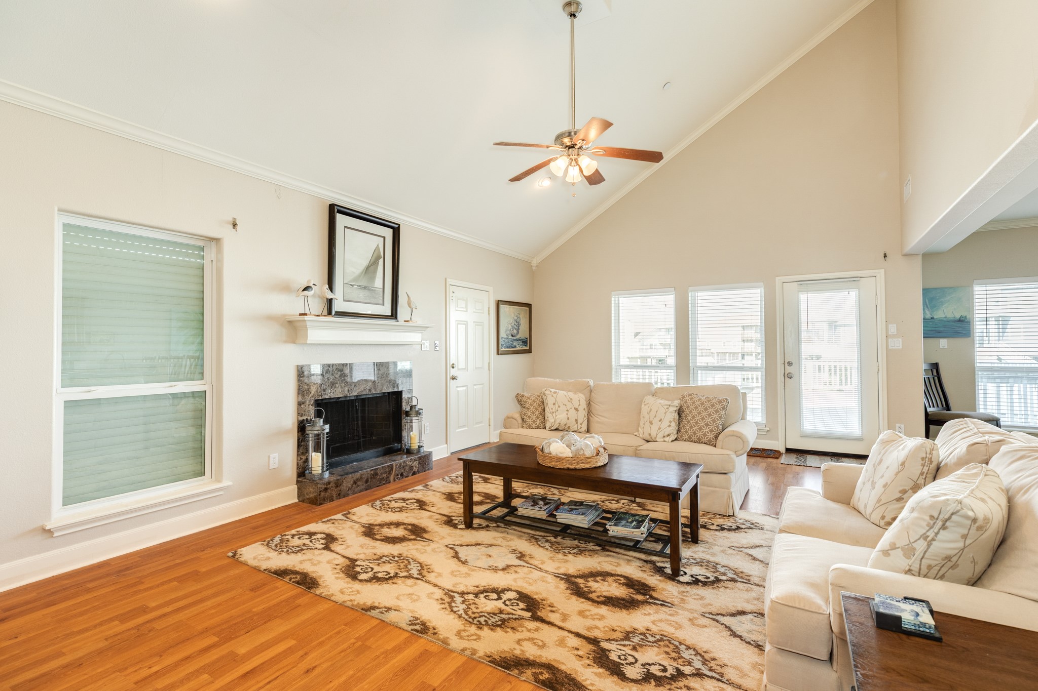 View of the living room looking towards the main deck and canal system. Windows and doors provide an abundance of natural light.