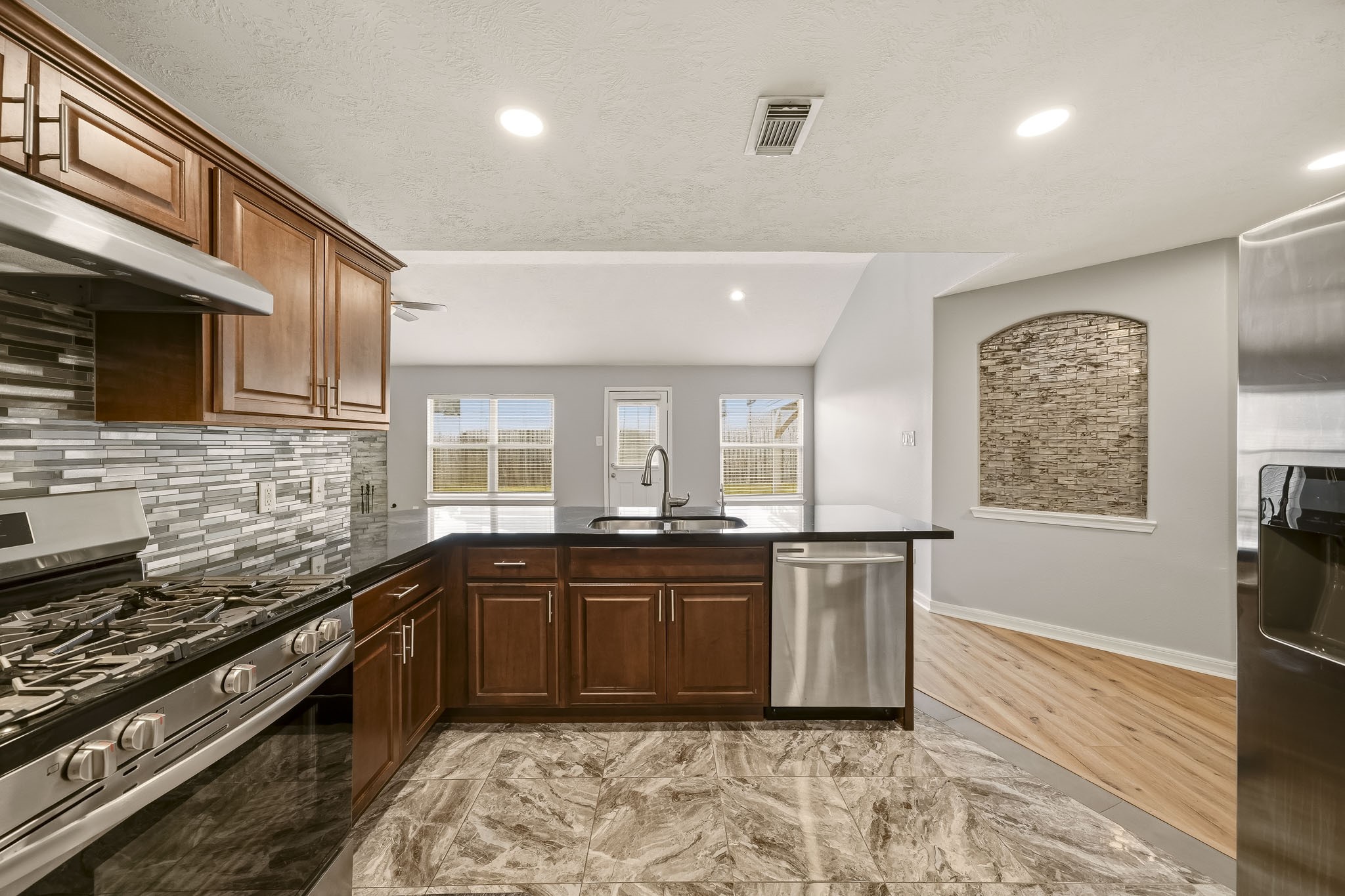 Renovated kitchen offers ample cabinetry, generous counter space, and recessed lighting.