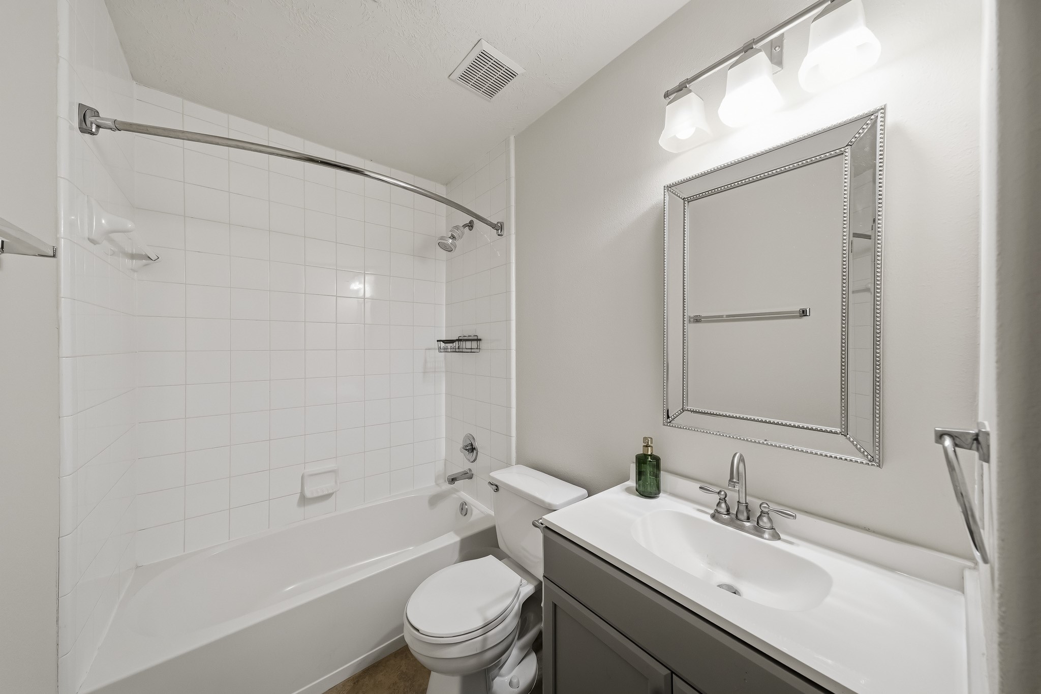 Updated secondary bath features a clean, modern vanity and neutral finishes.
