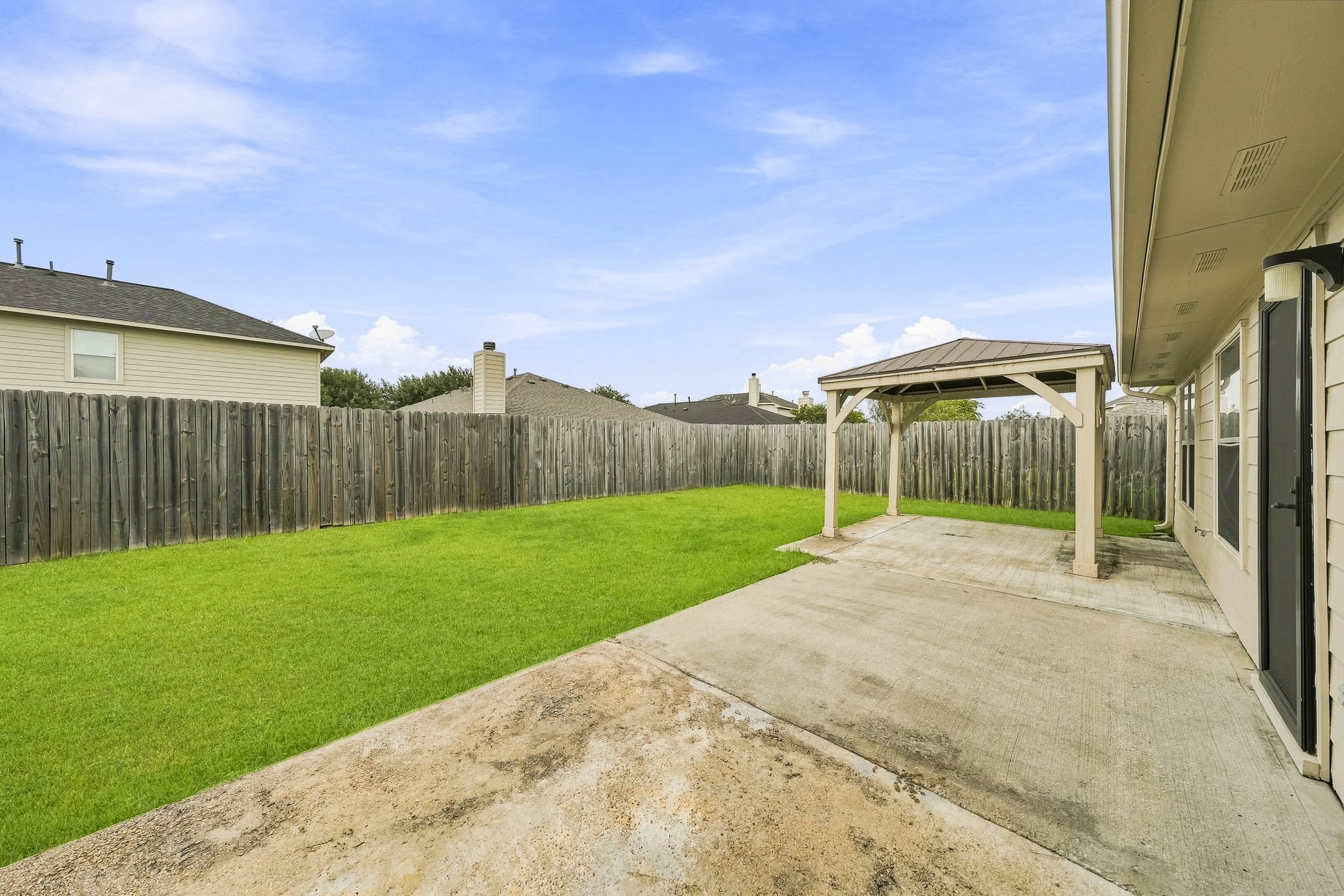 Covered patio overlooks the expansive backyard for easy outdoor enjoyment.