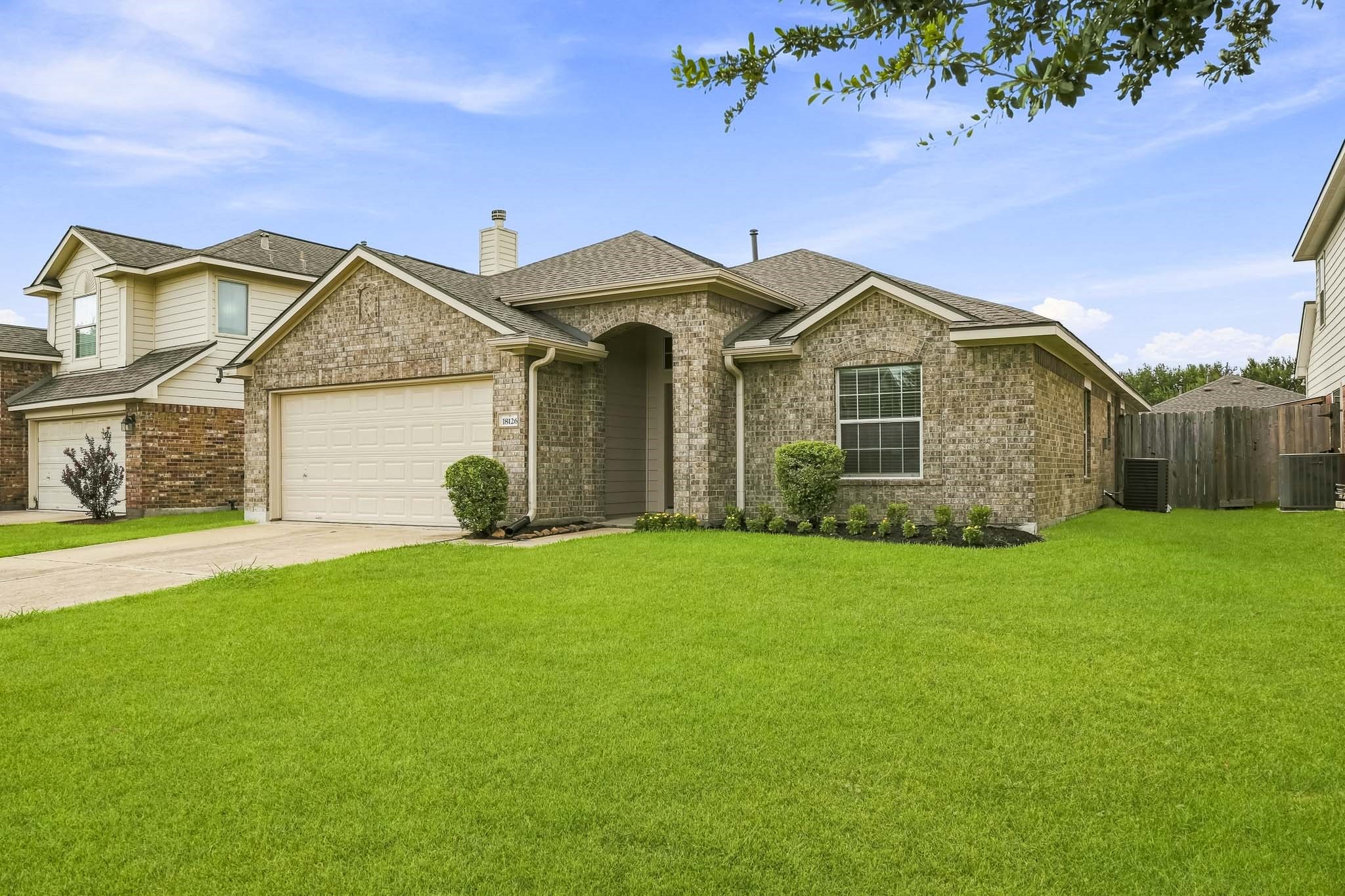 Well-maintained exterior surrounded by a spacious front lawn and mature landscaping.