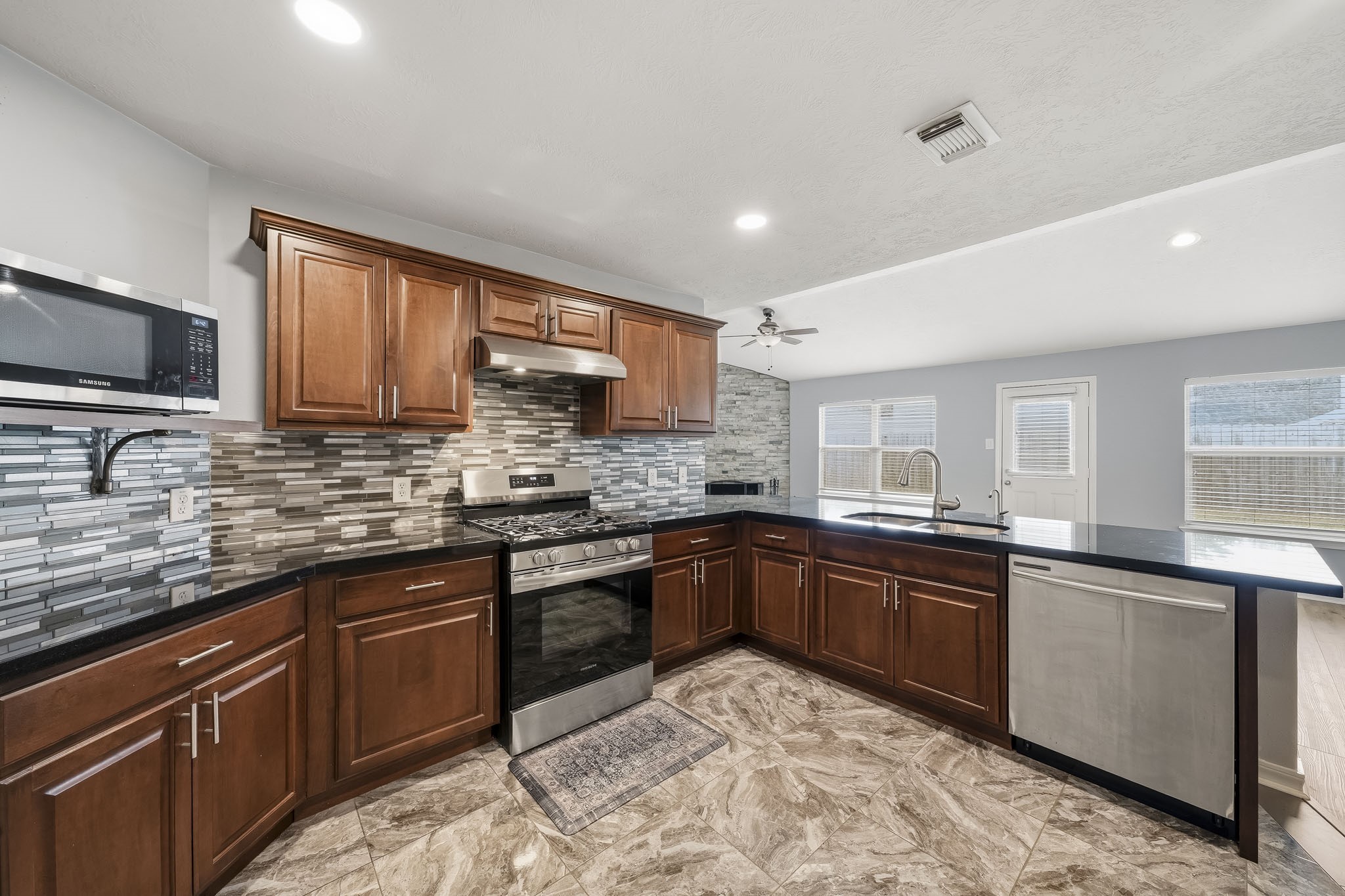 Updated kitchen features custom cabinetry, countertops, appliances, and modern finishes.