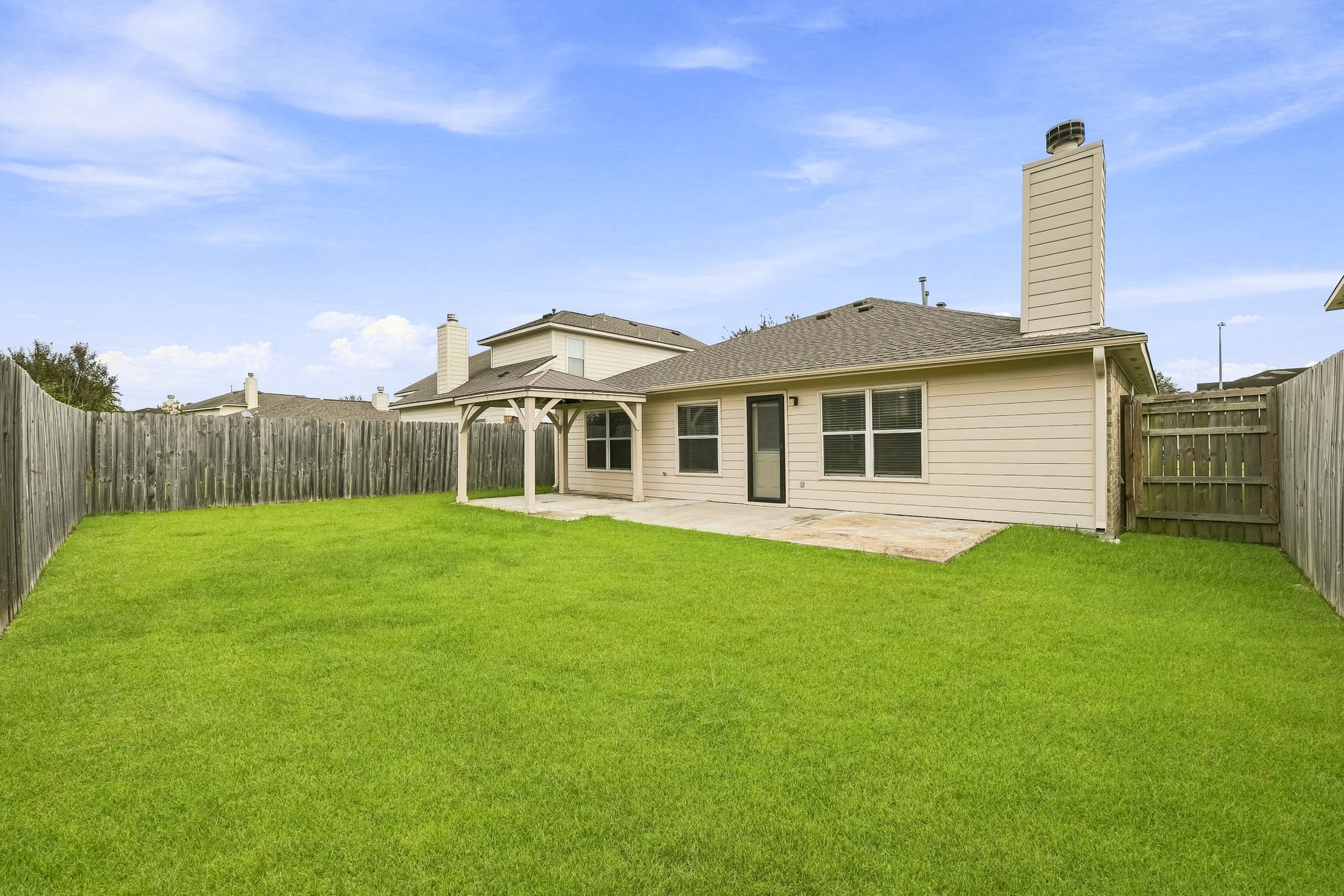 Spacious backyard offers an open lawn with room for outdoor activities and entertaining.