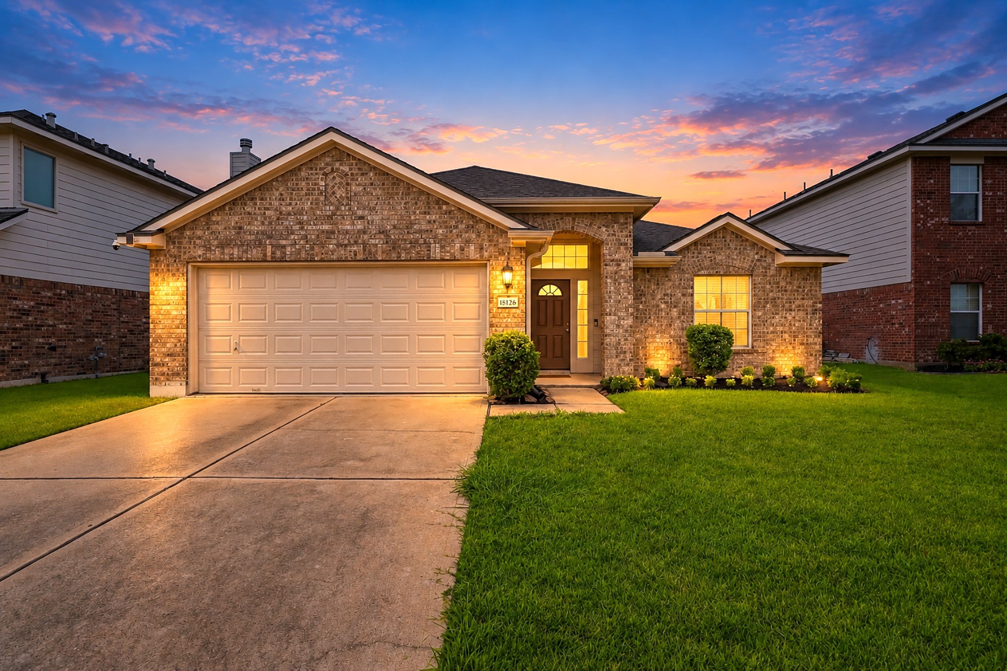 Charming single-story brick home with an attached two-car garage and welcoming curb appeal.