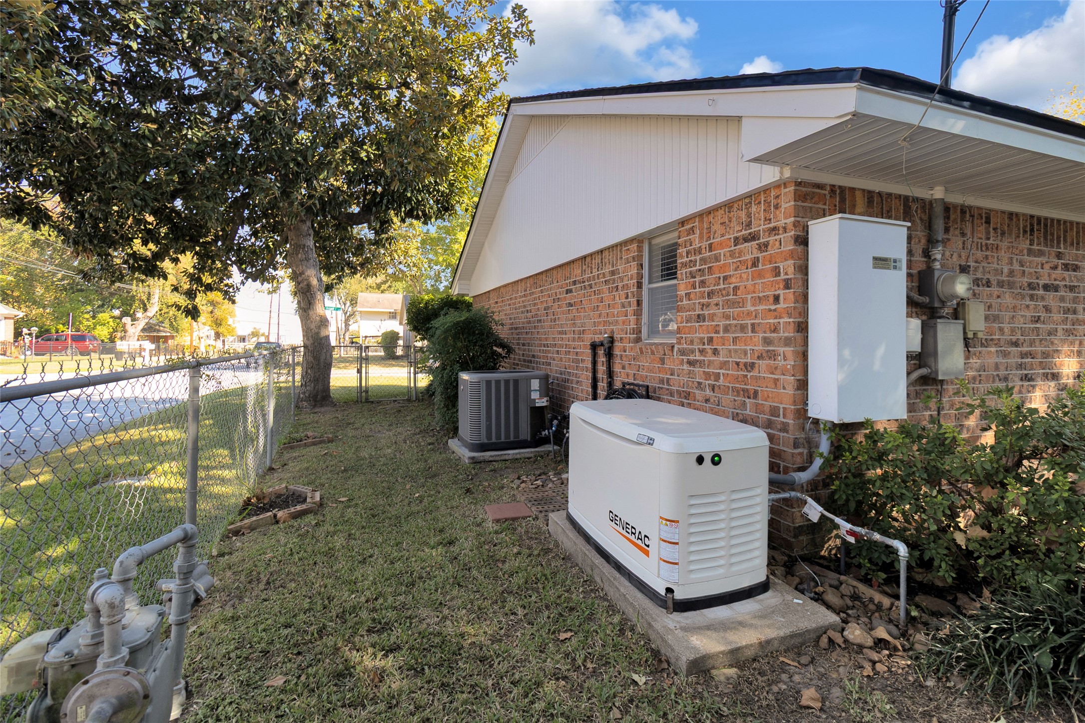 Brick exterior with a well-maintained yard, featuring a standby generator and modern HVAC system for reliable comfort and energy efficiency.