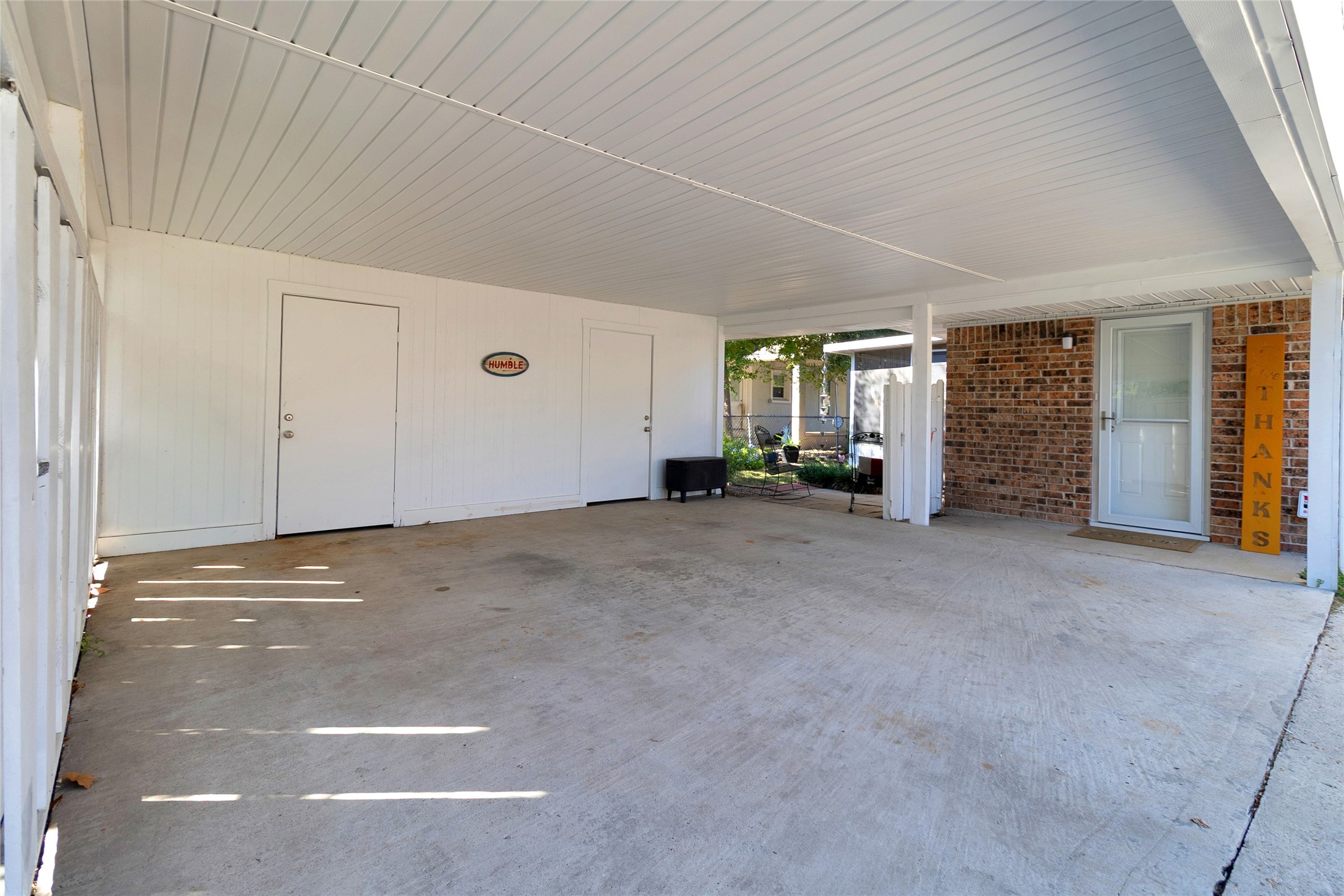 Spacious covered carport with clean lines and direct access to a welcoming brick entrance.