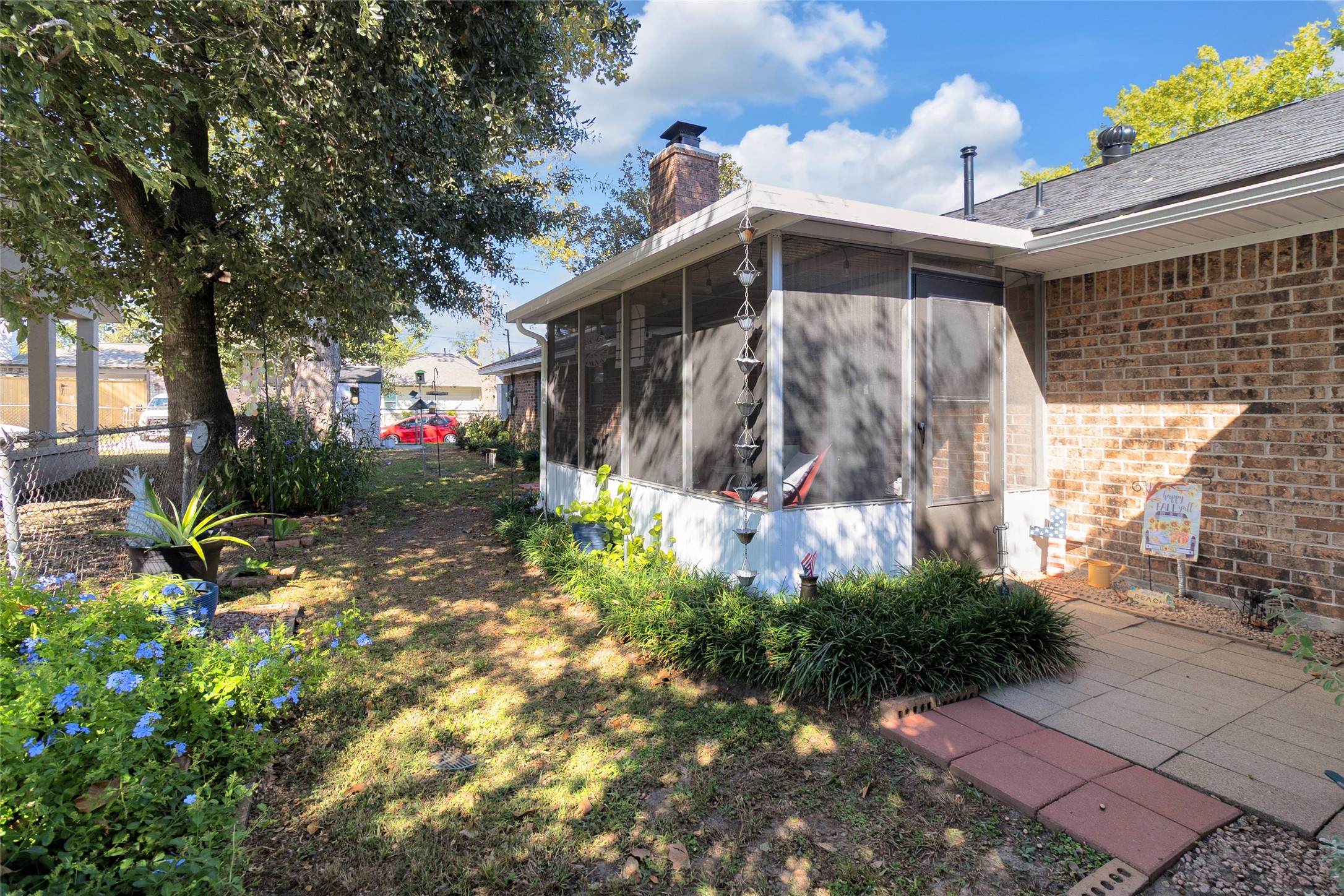 Charming backyard features a cozy screened-in porch, perfect for relaxing while enjoying the surrounding lush greenery and mature trees.