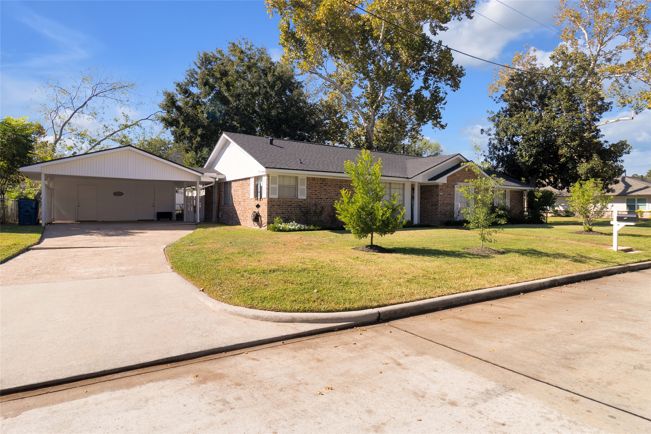 Angled view of the home showcasing its spacious driveway and convenient attached carport, offering ample parking space. Angled view of the home showcasing its spacious driveway and convenient attached carport, offering ample parking space.