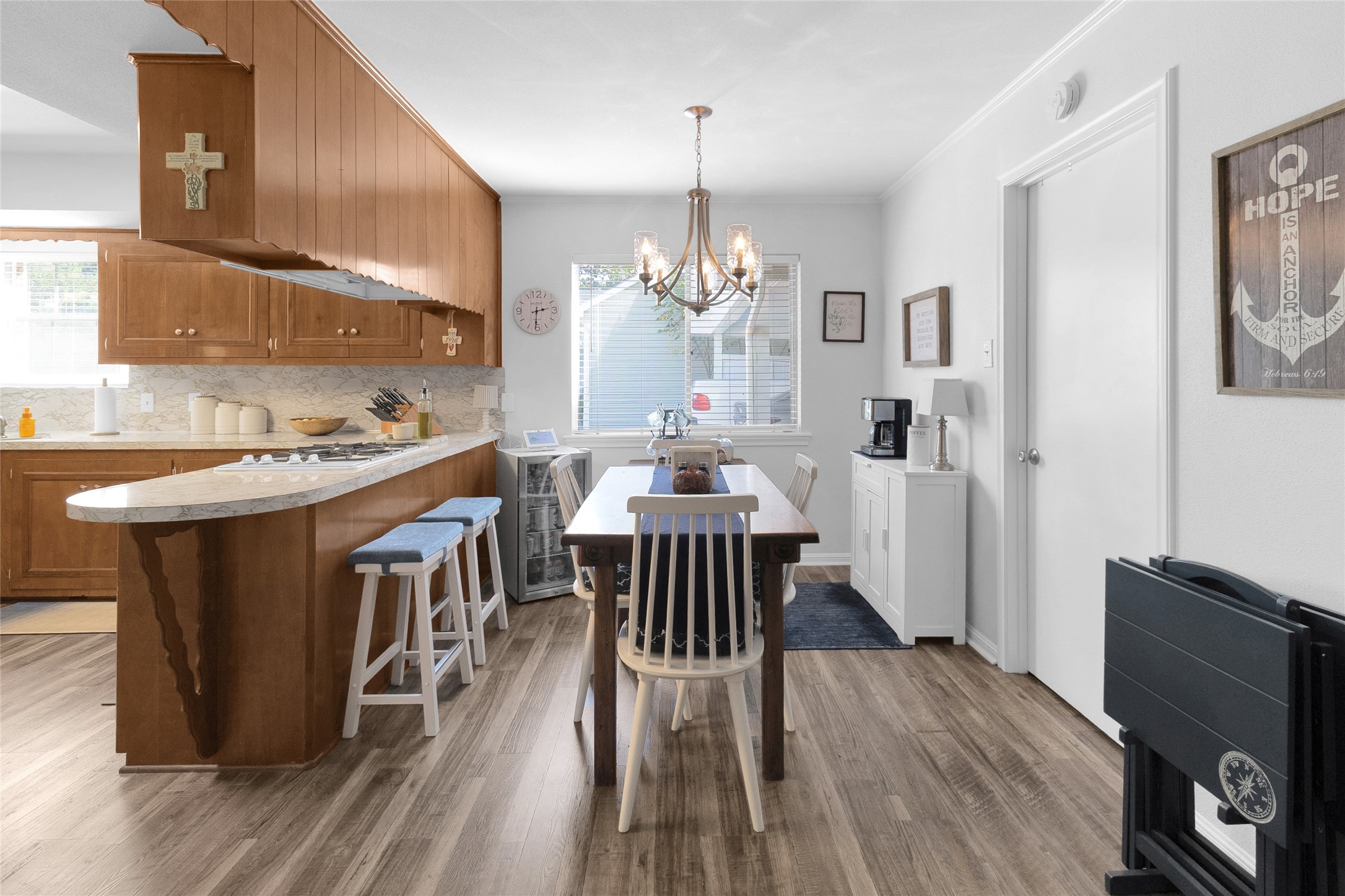 Charming breakfast area with a cozy breakfast bar, featuring warm wood cabinetry and a stylish chandelier, perfect for family meals and entertaining guests.