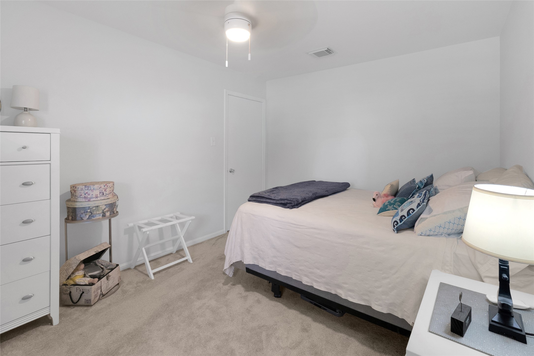 Spacious bedroom featuring soft carpeting, a modern ceiling fan, warm lighting, and plenty of room to personalize to your liking.