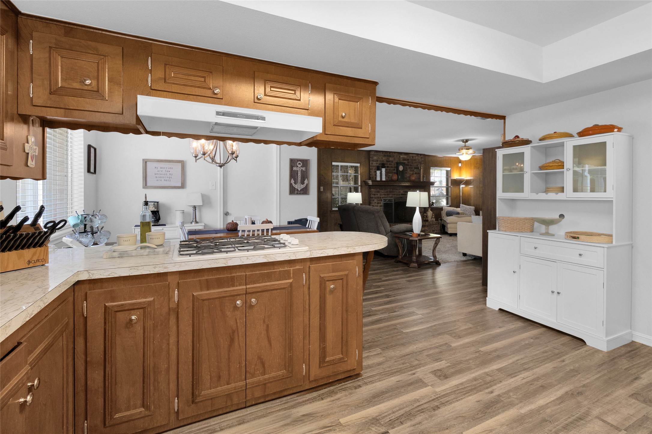Charming kitchen with warm wooden cabinetry and a cozy open layout leading to a spacious living area.
