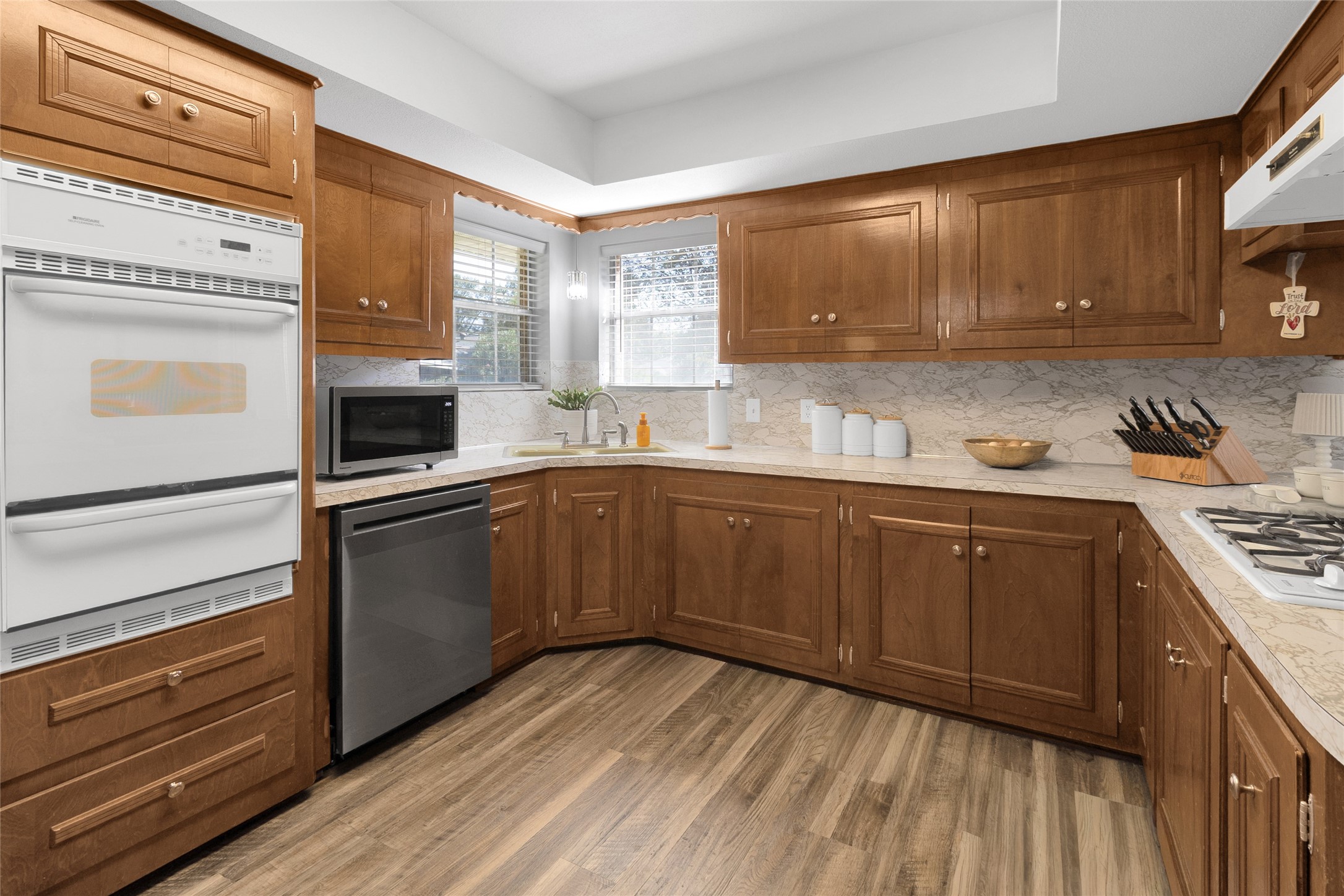 Charming kitchen with rich wooden cabinetry, sleek countertops, and modern appliances, offering a warm and inviting atmosphere perfect for culinary enthusiasts.