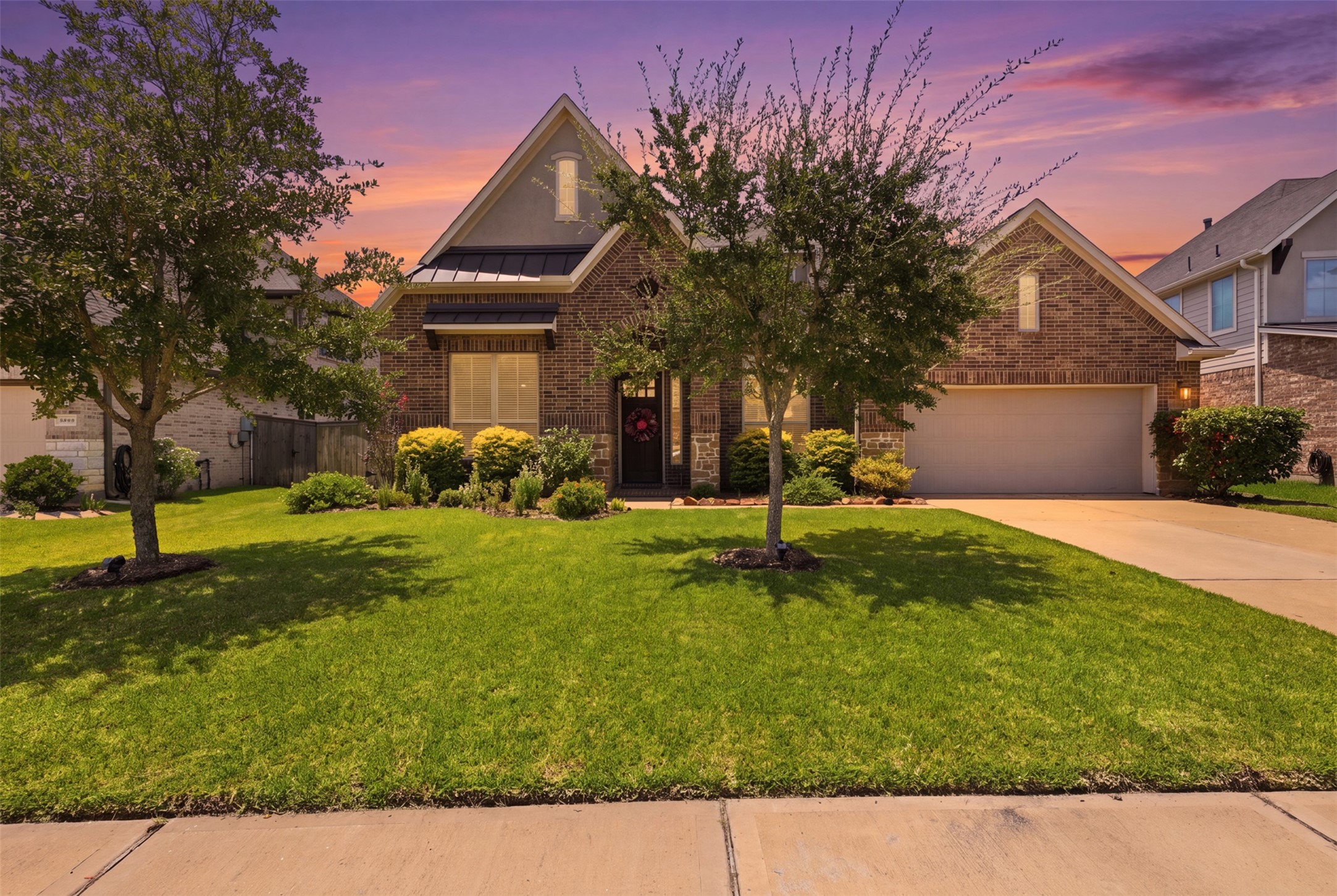Beautiful brick and stone exterior with mature landscaping and oversized driveway.