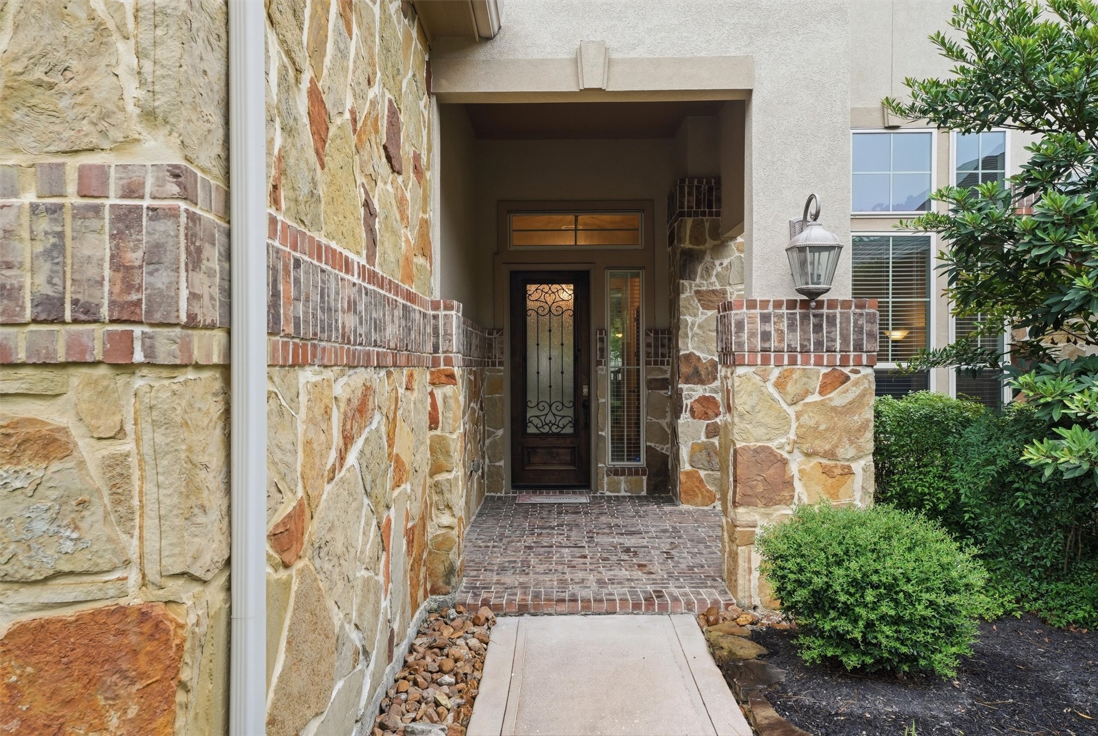 Beautiful Stone work leads you to a welcoming covered front porch.