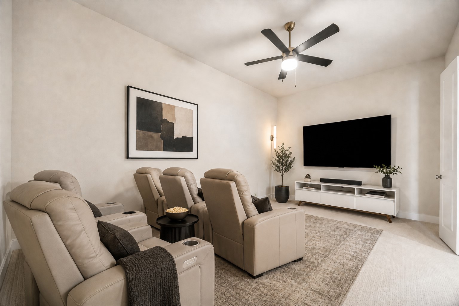 FIRST FLOOR ENTERTAINMENT ROOM OFFERS A GENEROUS LAYOUT, CEILING FAN, AND WALL SPACE IDEAL FOR A LARGE-SCREEN ENTERTAINMENT SETUP. **Virtually Staged.