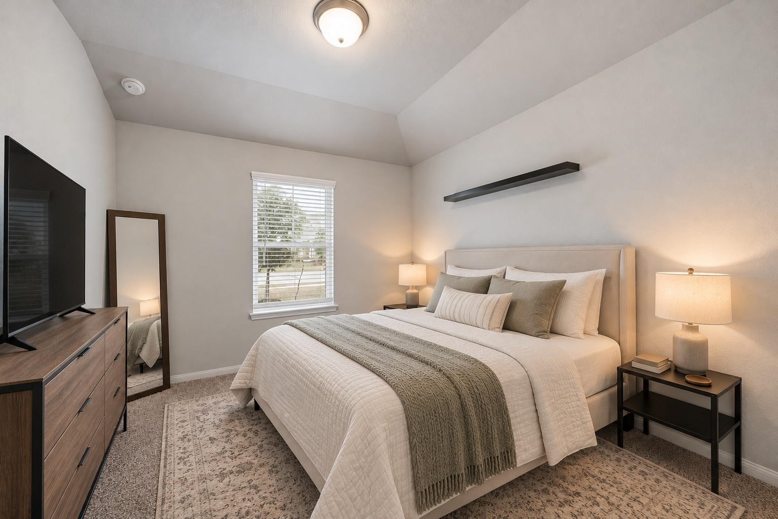 Virtually Staged: This comfortable secondary bedroom features a vaulted ceiling and plush carpeting that creates a cozy, inviting atmosphere. A centrally positioned window welcomes natural light into the space.