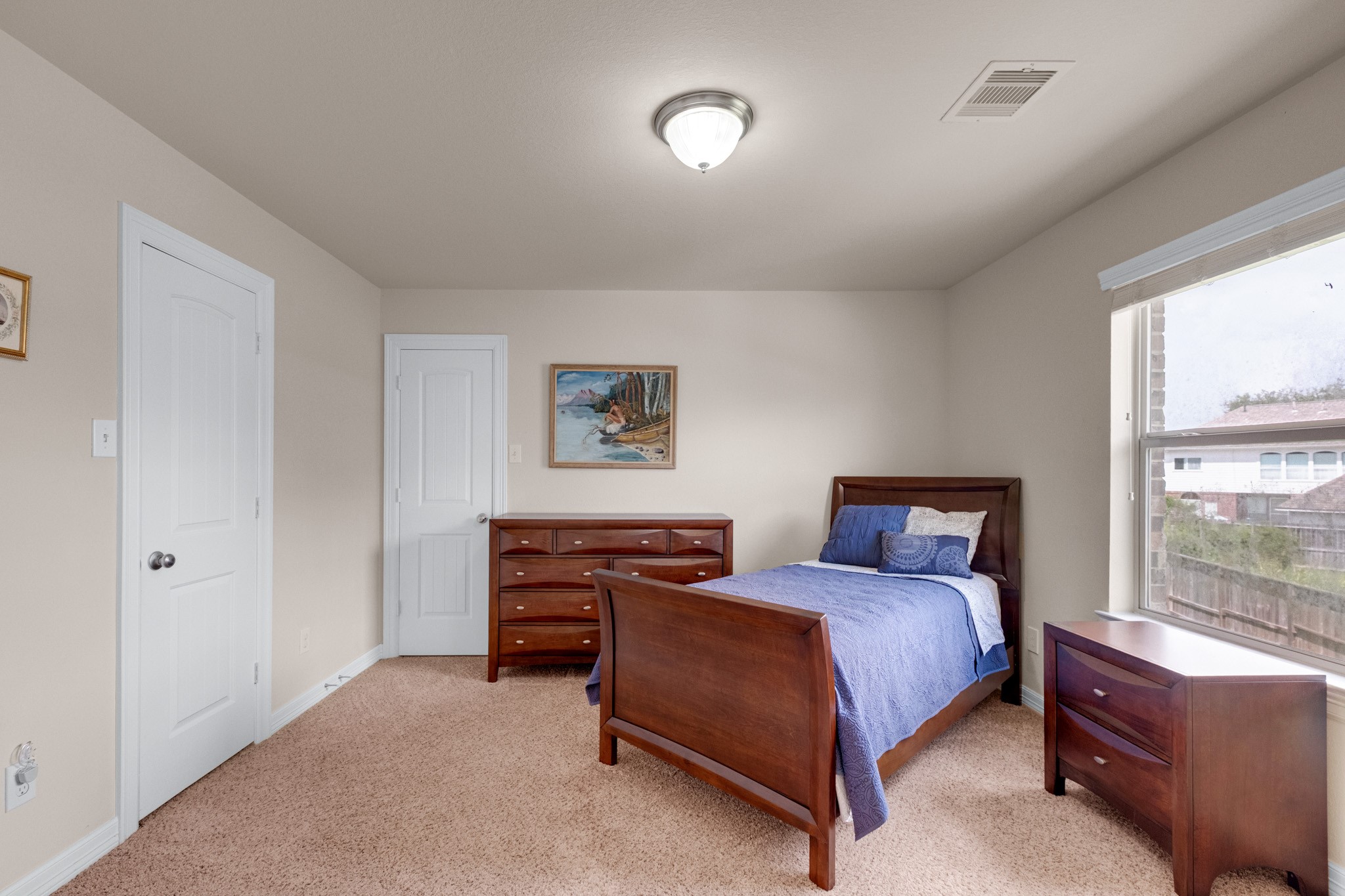 Another secondary bedroom carries plush carpet, a full window, and enough wall for a queen or twin set with dressers.